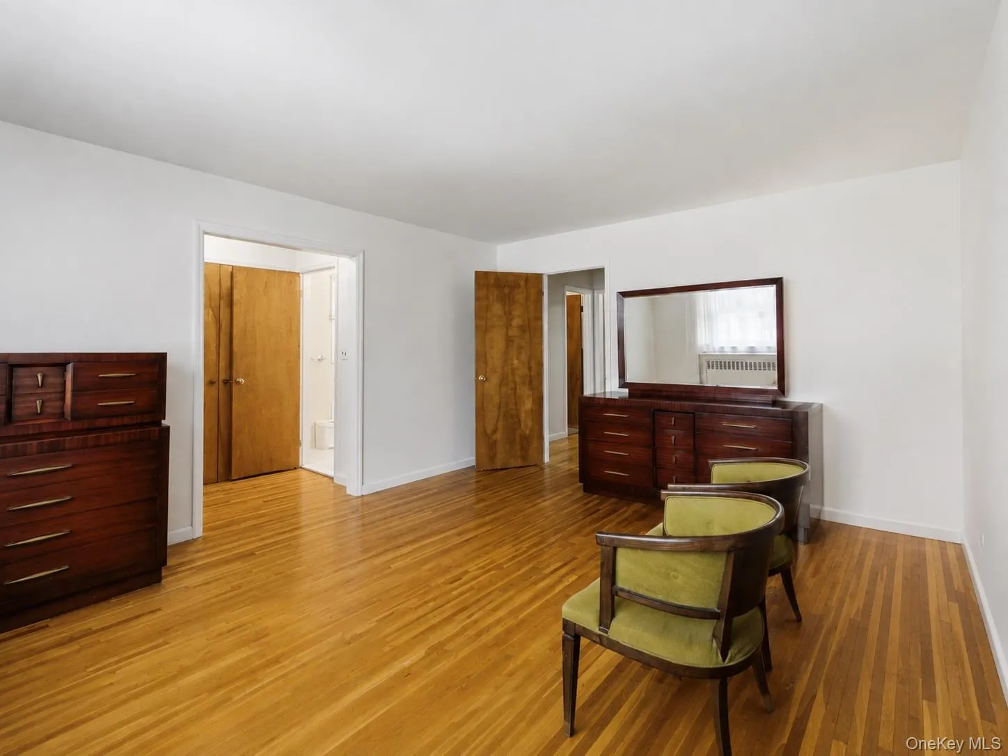 Spacious primary bedroom featuring hardwood floors, generous closet space, and a renovated en-suite bath. Spacious primary bedroom featuring hardwood floors, generous closet space, and a renovated en-suite bath.