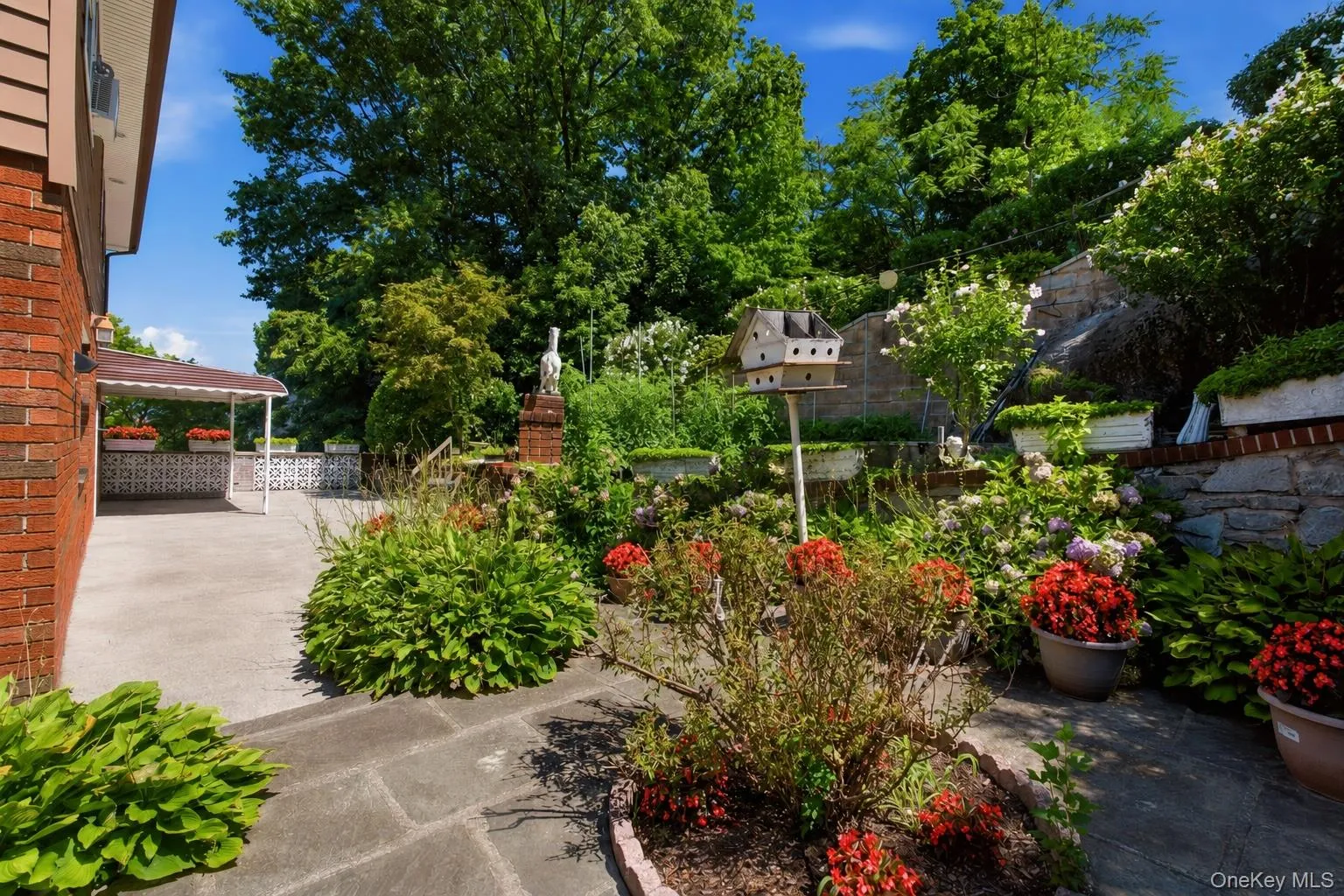 Inviting backyard patio surrounded by colorful plantings and thoughtfully landscaped outdoor space. Inviting backyard patio surrounded by colorful plantings and thoughtfully landscaped outdoor space.