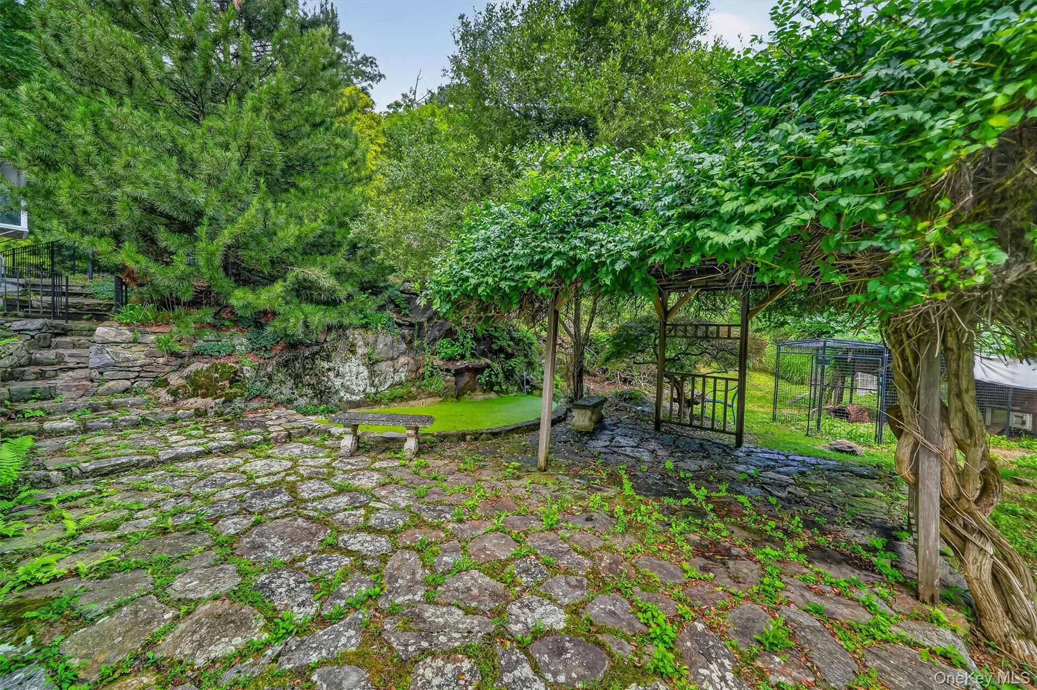 Stone paver patio with natural rock retaining wall Stone paver patio with natural rock retaining wall
