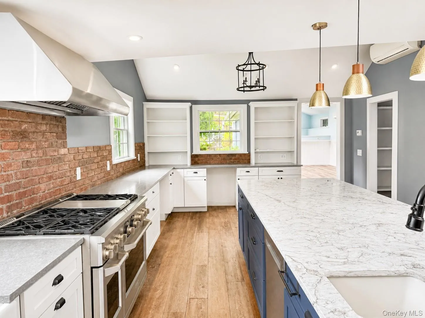 Chef's kitchen designed for both everyday living and entertaining, featuring a professional-grade dual-oven gas range with commercial-style hood, oversized waterfall island, quartz countertops, custom cabinetry, open shelving, Chef's kitchen designed for both everyday living and entertaining, featuring a professional-grade dual-oven gas range with commercial-style hood, oversized waterfall island, quartz countertops, custom cabinetry, open shelving,