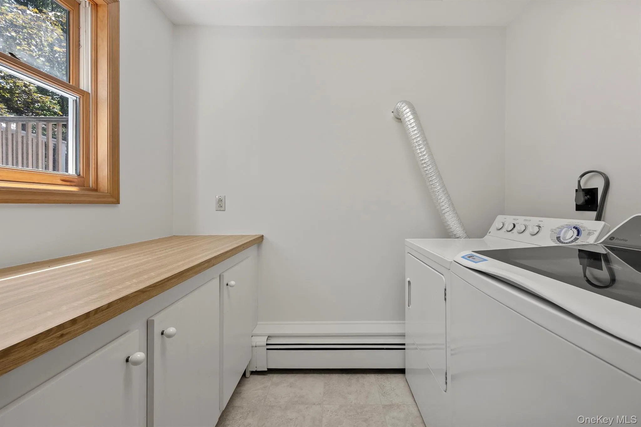 A dedicated laundry room with storage and a long folding counter A dedicated laundry room with storage and a long folding counter