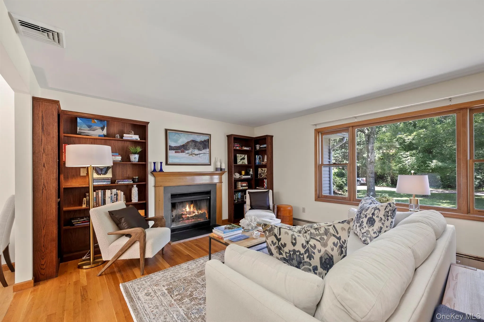 Spacious living room is framed by elegant fireplace and lots of windows Spacious living room is framed by elegant fireplace and lots of windows