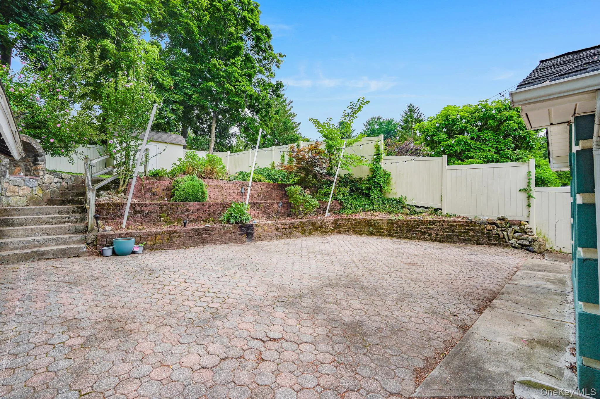 Sprawling patio area with terraced yard Sprawling patio area with terraced yard
