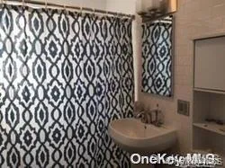 Bathroom featuring curtained shower and tile walls Bathroom featuring curtained shower and tile walls