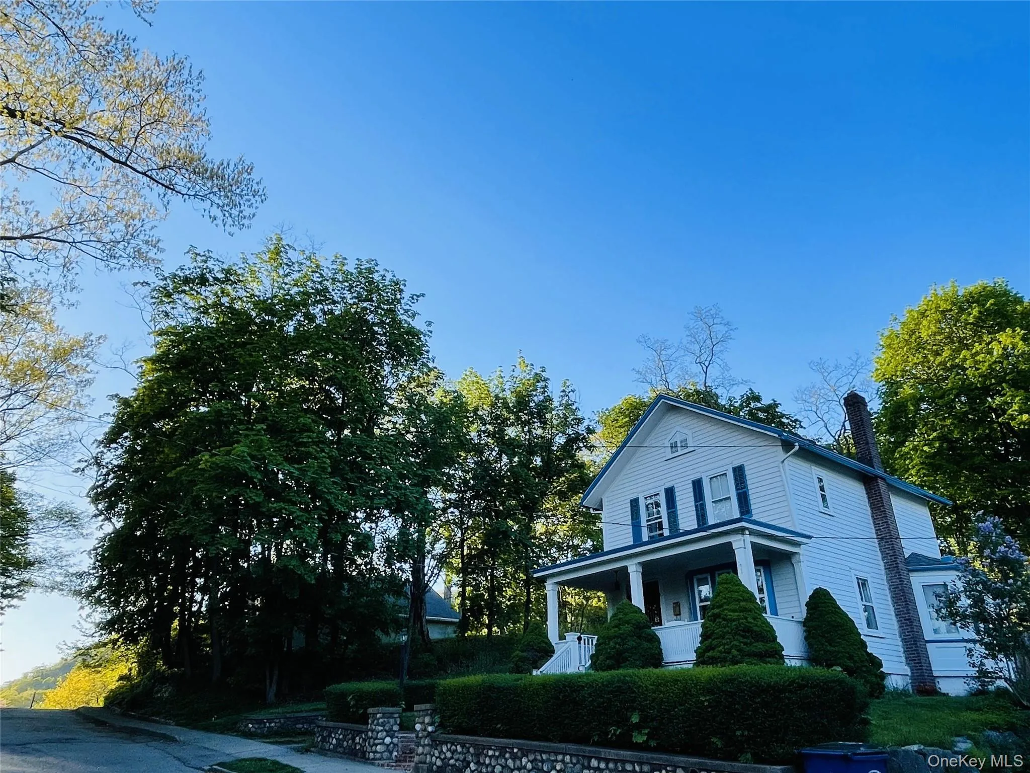 View of front of property featuring covered porch and charming stone wall View of front of property featuring covered porch and charming stone wall