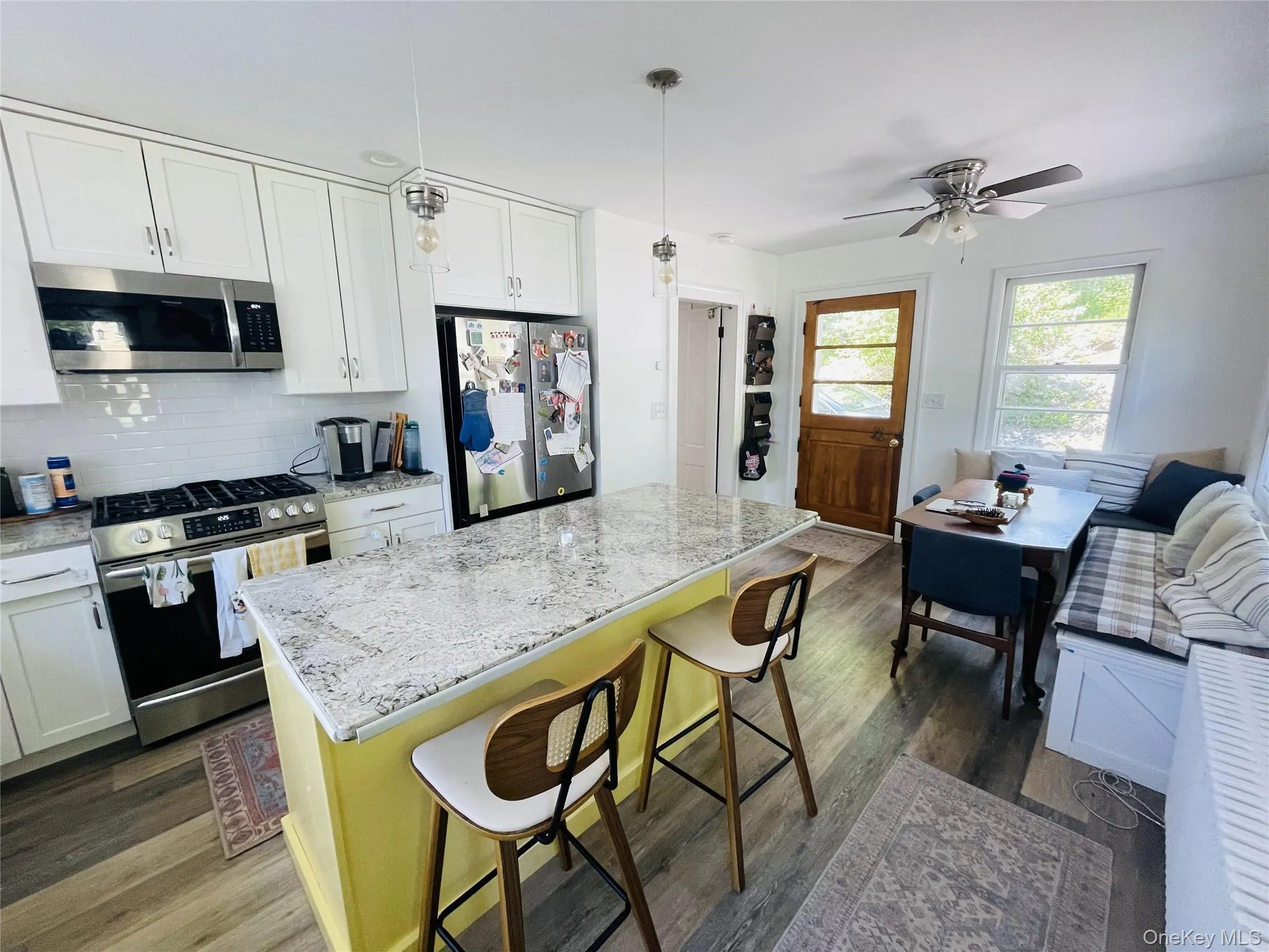 Kitchen with new stainless steel appliances, tasteful backsplash, a kitchen breakfast bar and wood floors Kitchen with new stainless steel appliances, tasteful backsplash, a kitchen breakfast bar and wood floors