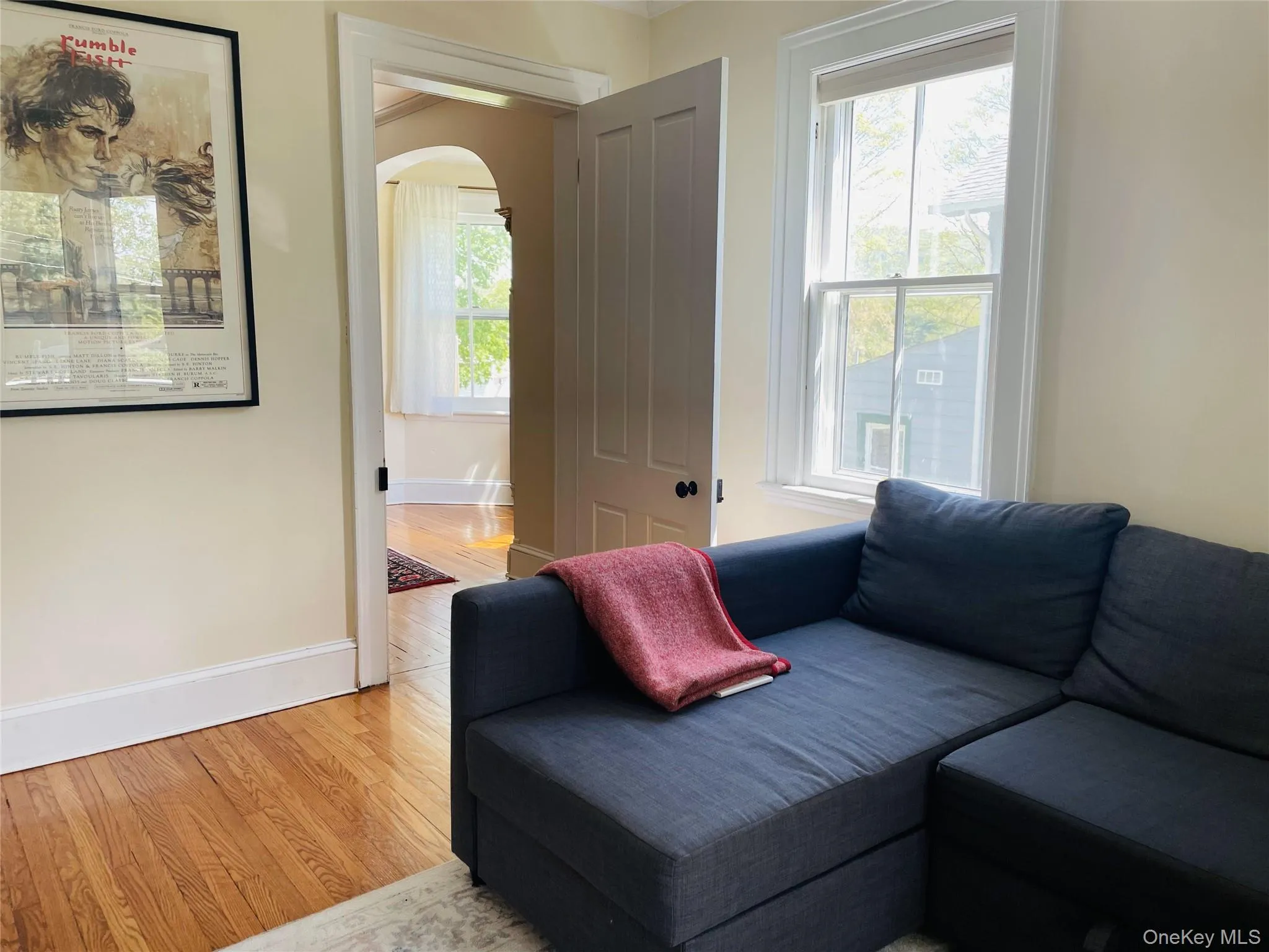Living area featuring baseboards, arched walkways, and light wood finished floors Living area featuring baseboards, arched walkways, and light wood finished floors