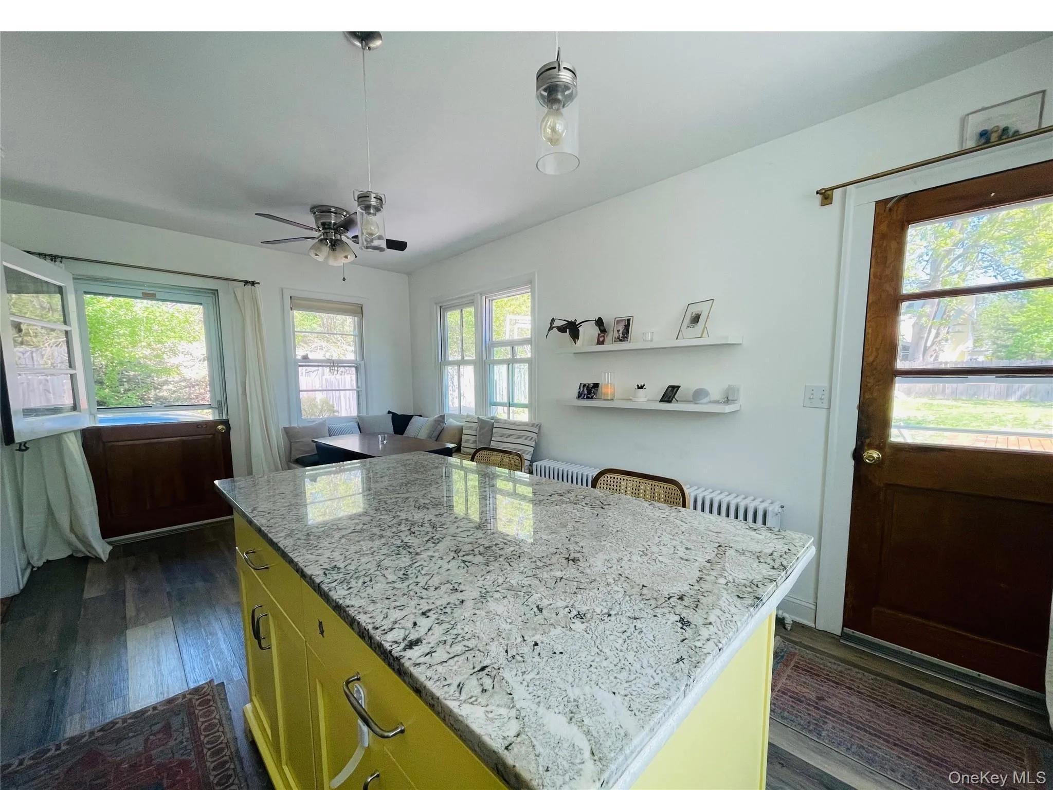 Kitchen featuring ceiling fan, light stone countertops, a kitchen island, and wood floors Kitchen featuring ceiling fan, light stone countertops, a kitchen island, and wood floors