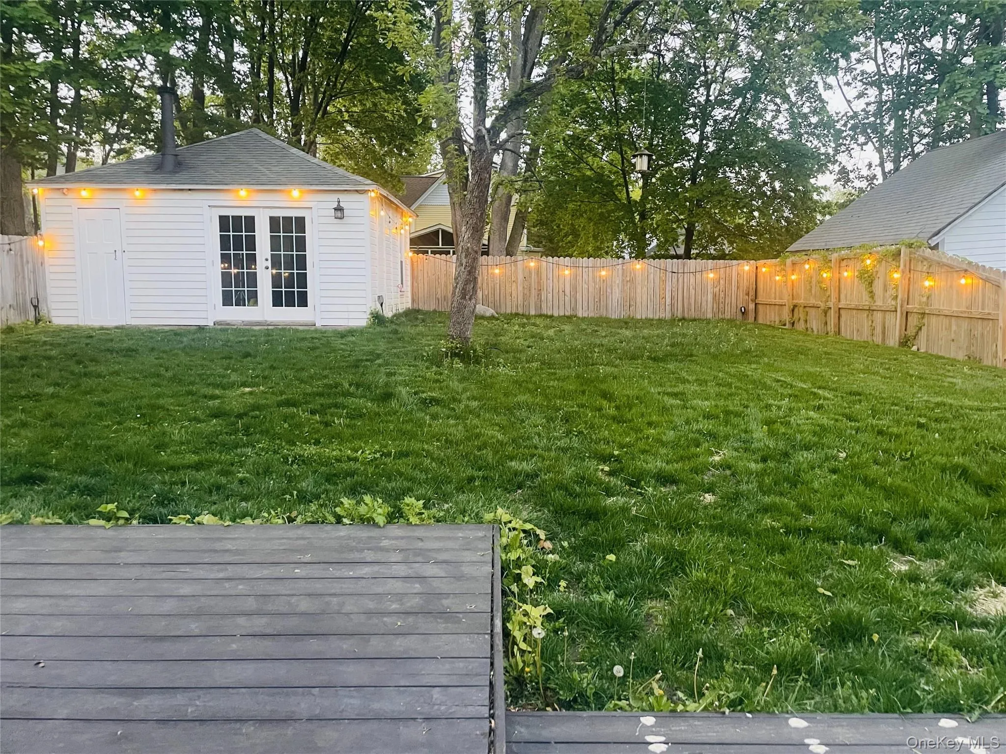 View of fenced backyard featuring deck with outdoor fan View of fenced backyard featuring deck with outdoor fan