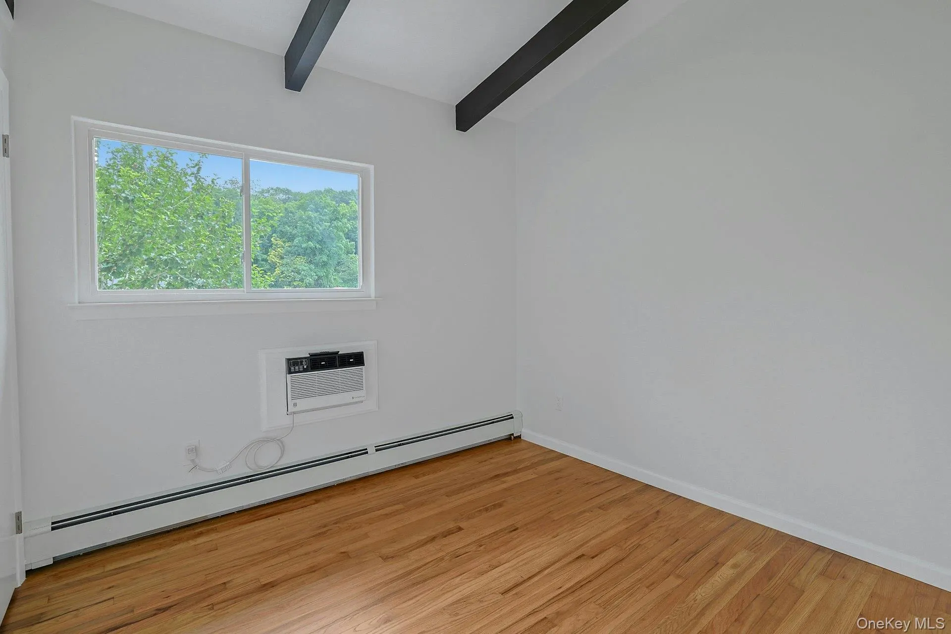 Bedroom # 1 with hardwood floor and beamed ceiling Bedroom # 1 with hardwood floor and beamed ceiling