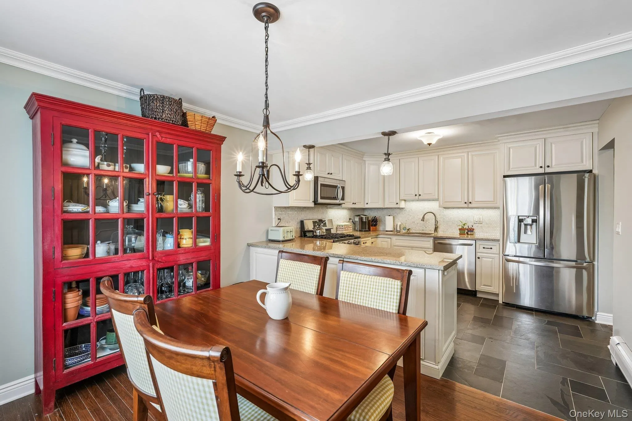 Dining area featuring wood-finish flooring, a chandelier, and crown molding Dining area featuring wood-finish flooring, a chandelier, and crown molding