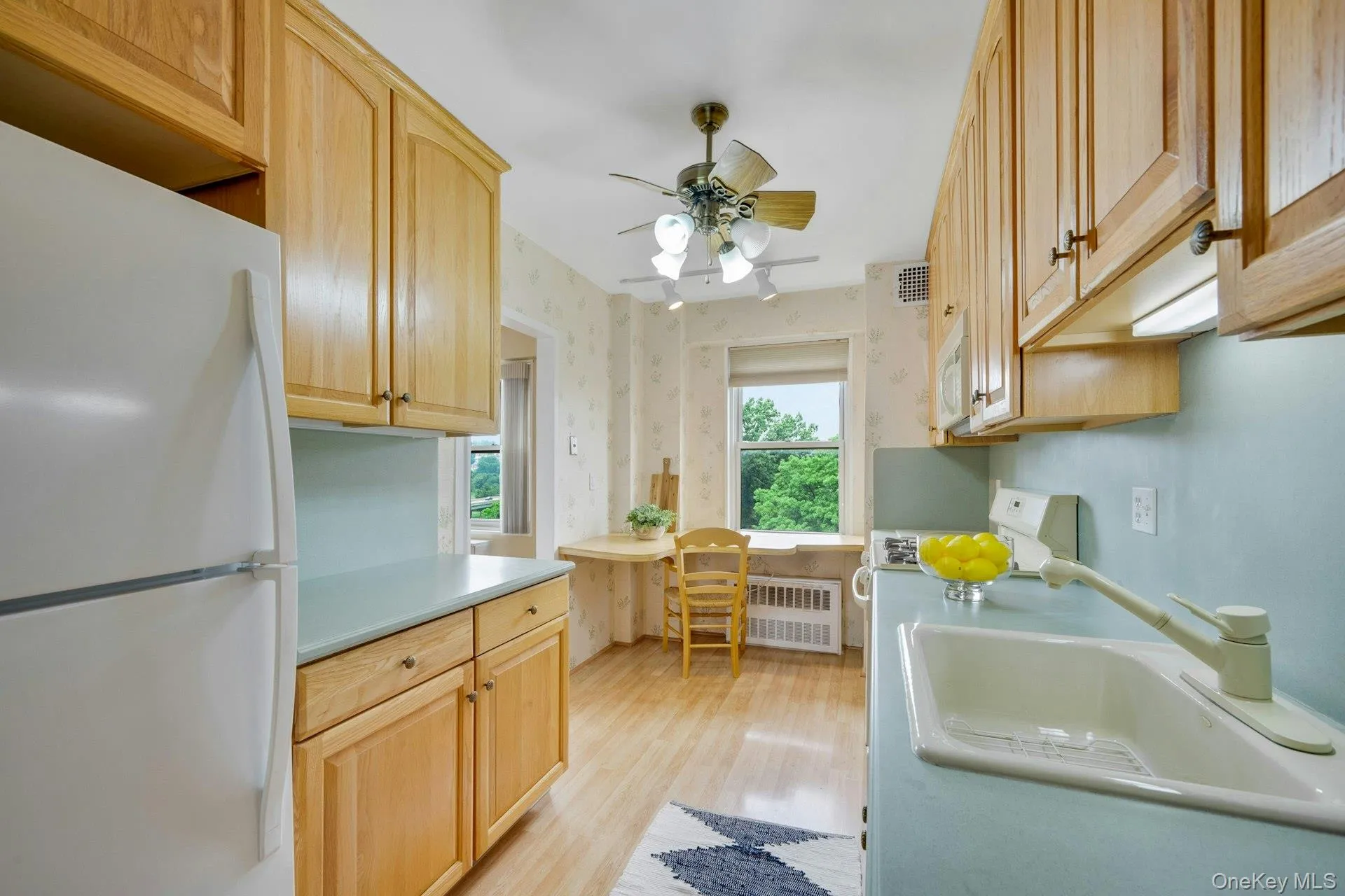Sunny eat-in kitchen with abundant cabinetry, generous counter space, and a dedicated dining nook. Sunny eat-in kitchen with abundant cabinetry, generous counter space, and a dedicated dining nook.
