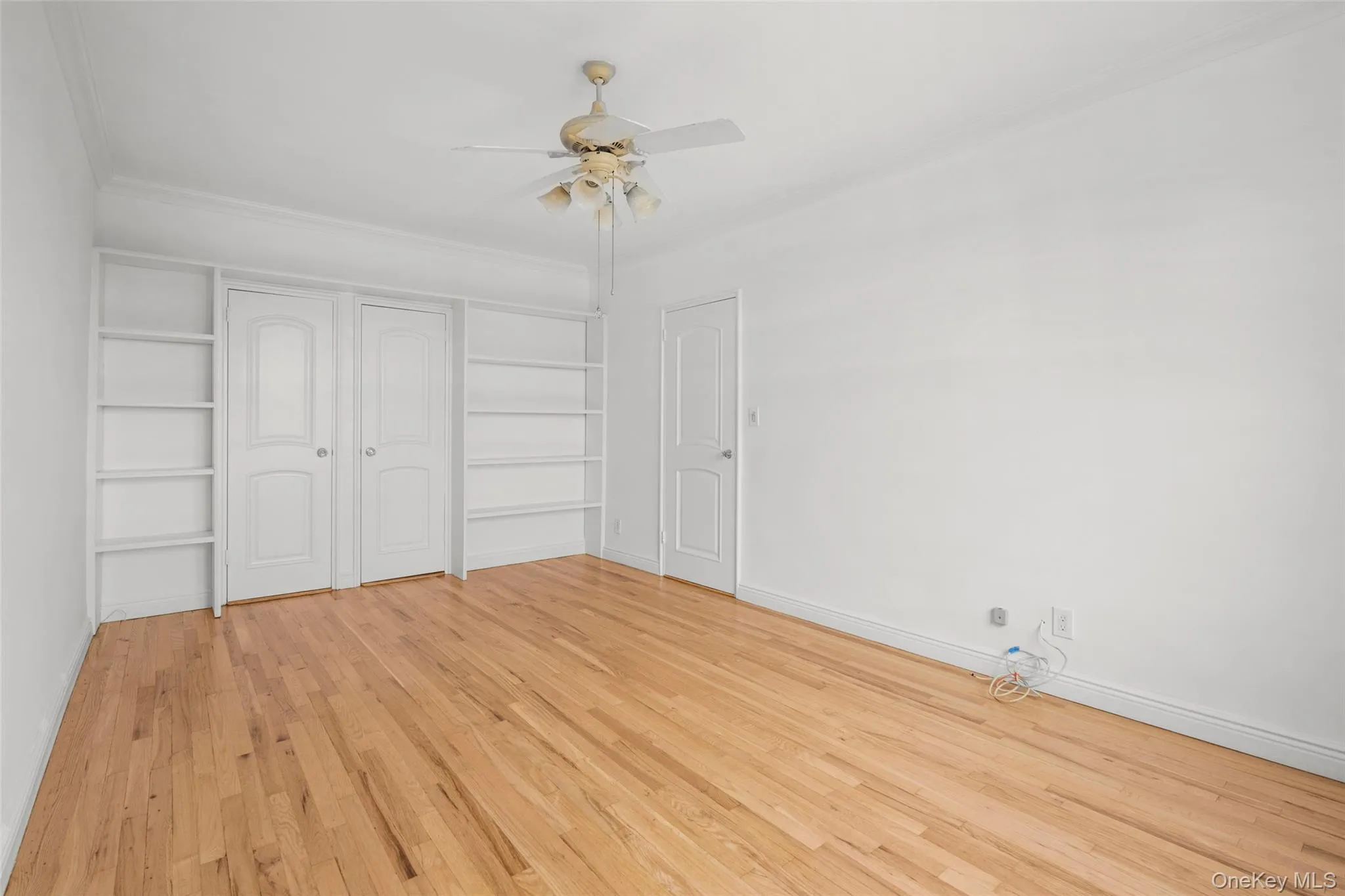 Bright and versatile, the second bedroom is appointed with freshly refinished oak floors, crown molding, built-in shelving, and spacious double closets. Bright and versatile, the second bedroom is appointed with freshly refinished oak floors, crown molding, built-in shelving, and spacious double closets.