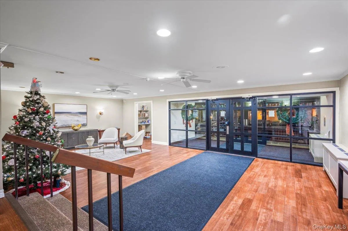 Spacious common area featuring wood-finish flooring, recessed lighting, and a glass-paneled entry system Spacious common area featuring wood-finish flooring, recessed lighting, and a glass-paneled entry system