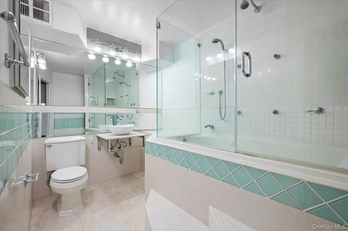 Bathroom featuring a glass-enclosed soaking tub and shower with multiple showerheads Bathroom featuring a glass-enclosed soaking tub and shower with multiple showerheads