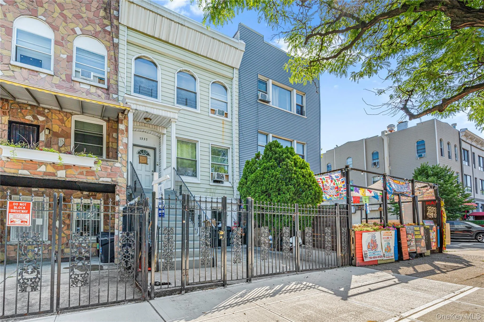 Light-colored facade with prominent entry staircase and wrought iron fencing Light-colored facade with prominent entry staircase and wrought iron fencing
