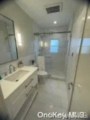 Bathroom featuring a stall shower and vanity Bathroom featuring a stall shower and vanity