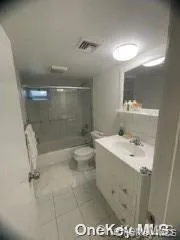 Bathroom featuring bathtub / shower combination, vanity, and tile patterned floors Bathroom featuring bathtub / shower combination, vanity, and tile patterned floors