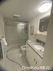Full bath with a shower stall, vanity, and tile patterned floors Full bath with a shower stall, vanity, and tile patterned floors