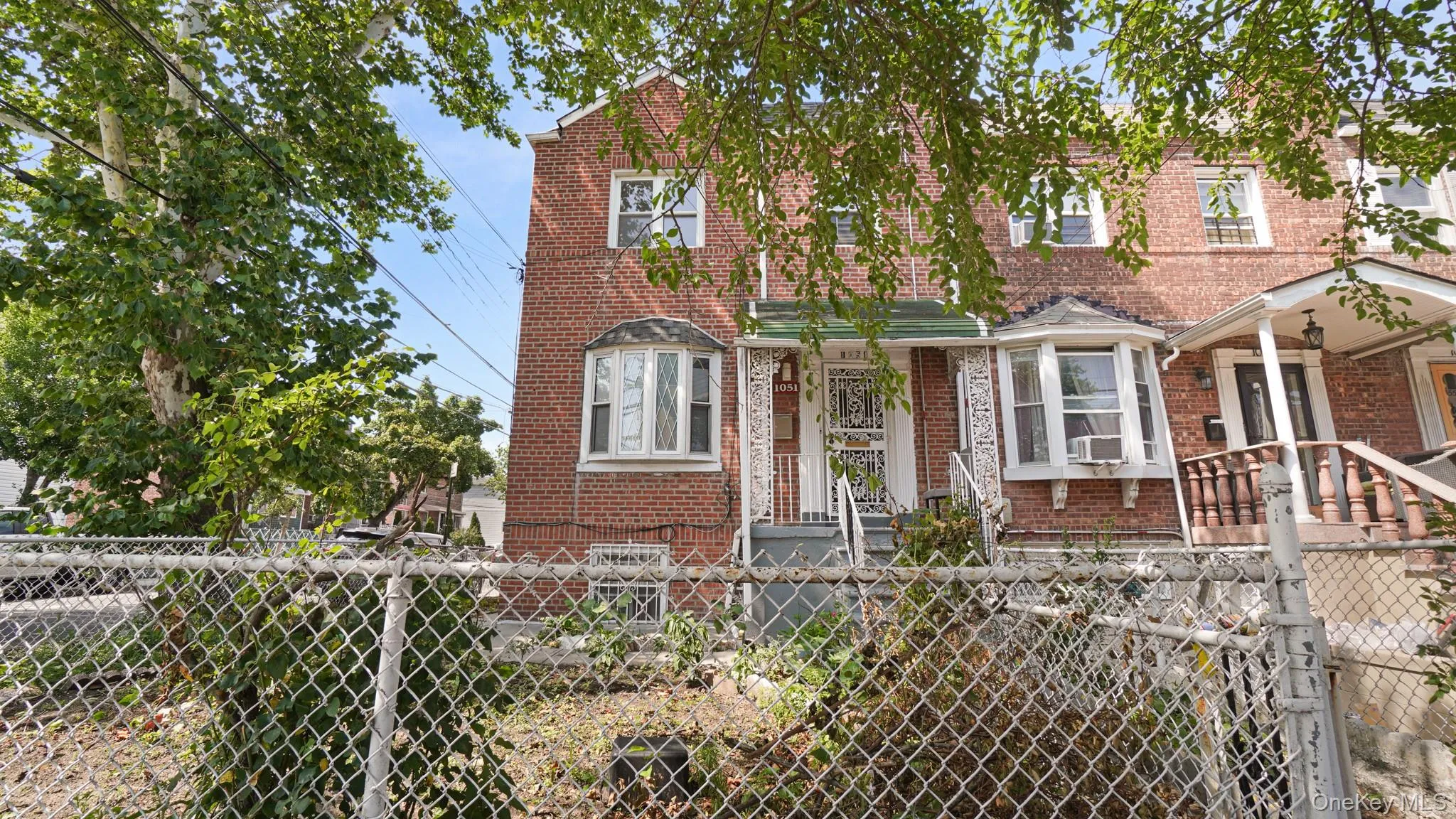 Brick facade residence featuring a bay window, covered front entrance, and an additional upper-level window Brick facade residence featuring a bay window, covered front entrance, and an additional upper-level window