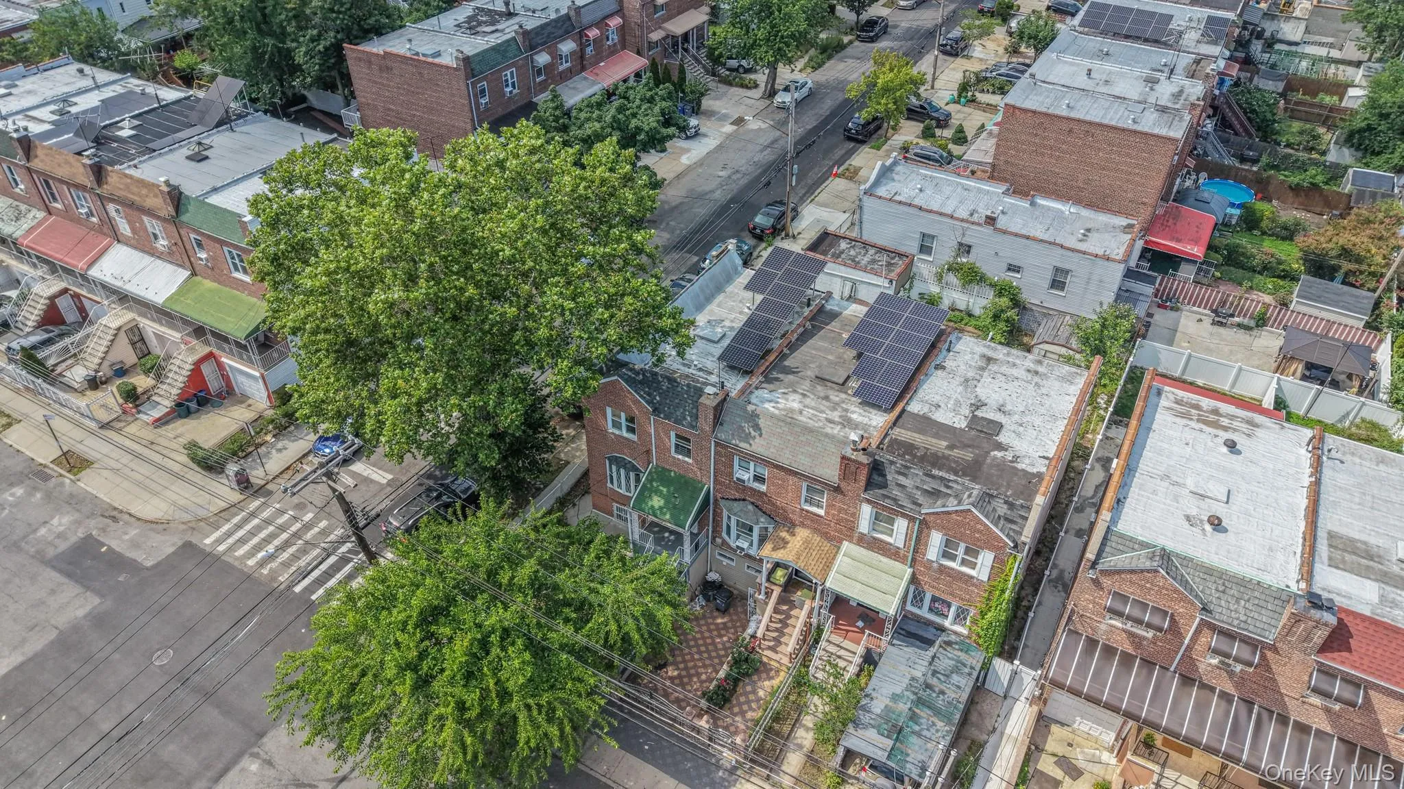 Brick-front row home featuring solar panels on the roof and an awning over the front entrance Brick-front row home featuring solar panels on the roof and an awning over the front entrance