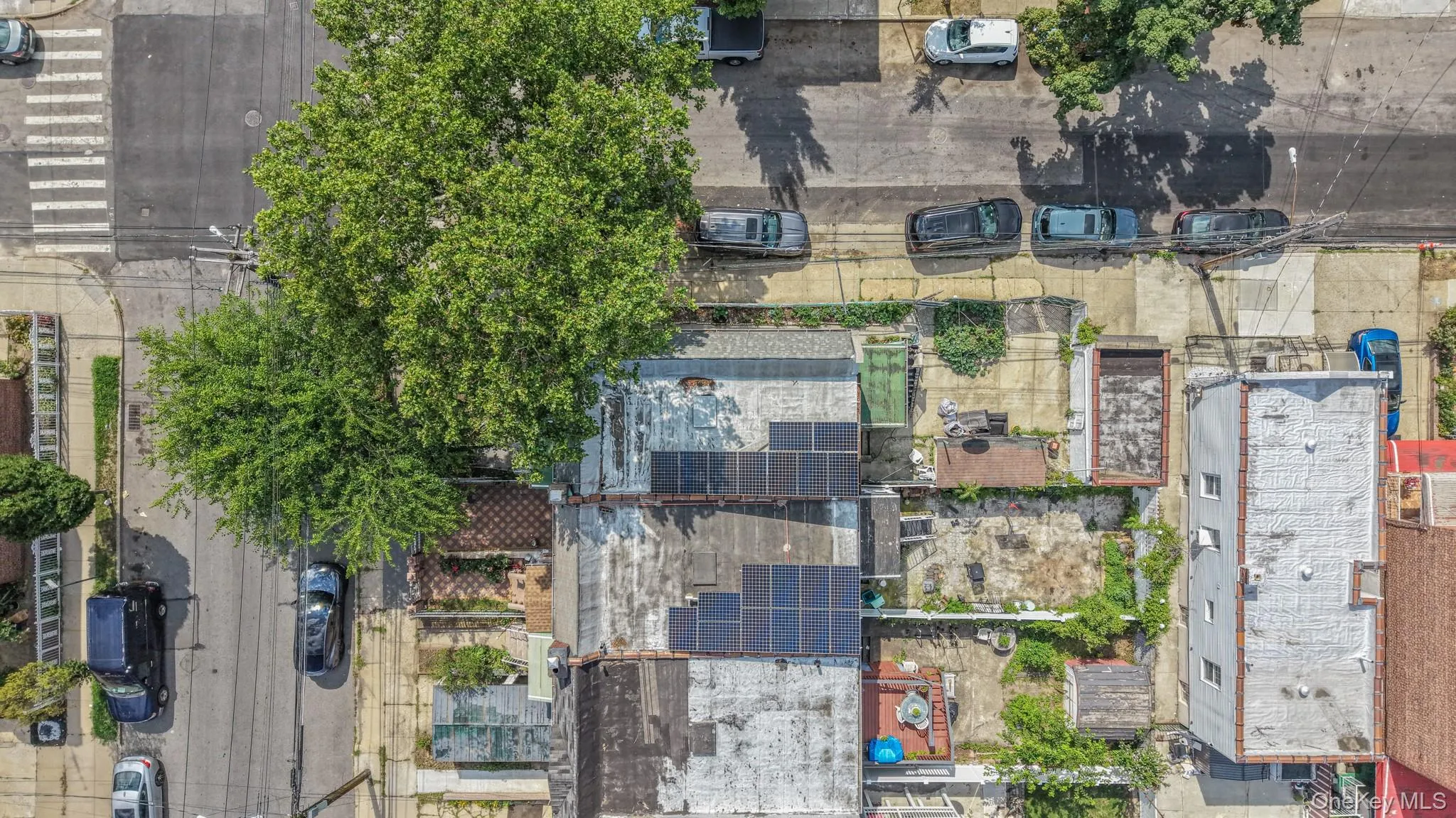 Aerial perspective showcasing multiple rooftops, including one with a solar panel array Aerial perspective showcasing multiple rooftops, including one with a solar panel array