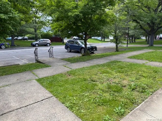 View of grassy front yard with designated 2 parking spots in front of the entrance of the townhouse. View of grassy front yard with designated 2 parking spots in front of the entrance of the townhouse.