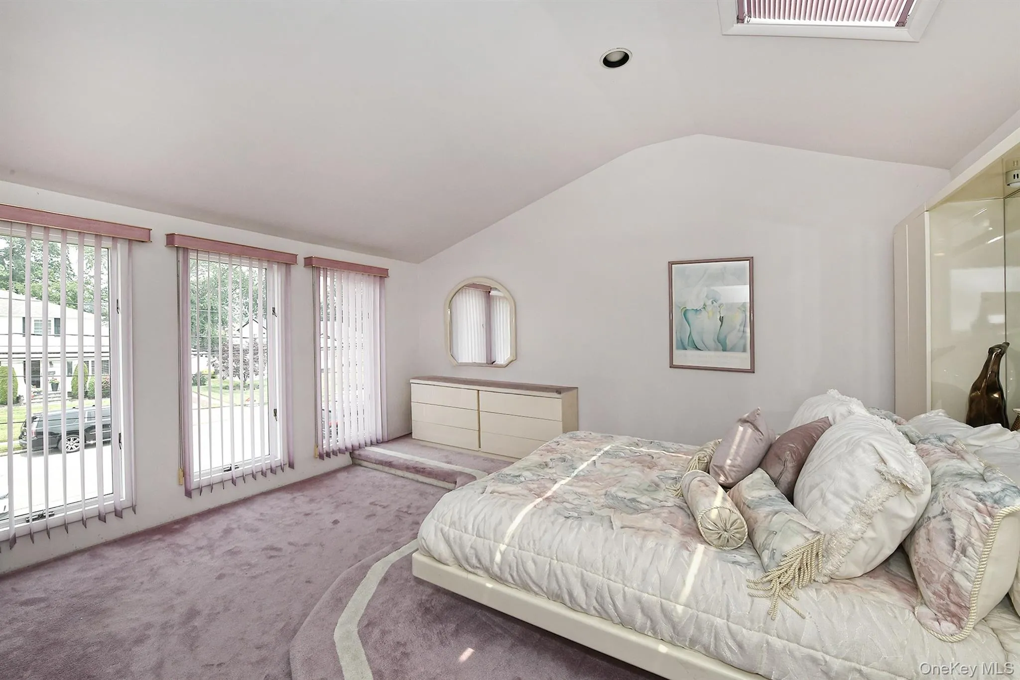 Vaulted ceiling room with three vertical windows, a built-in display case, and a skylight Vaulted ceiling room with three vertical windows, a built-in display case, and a skylight