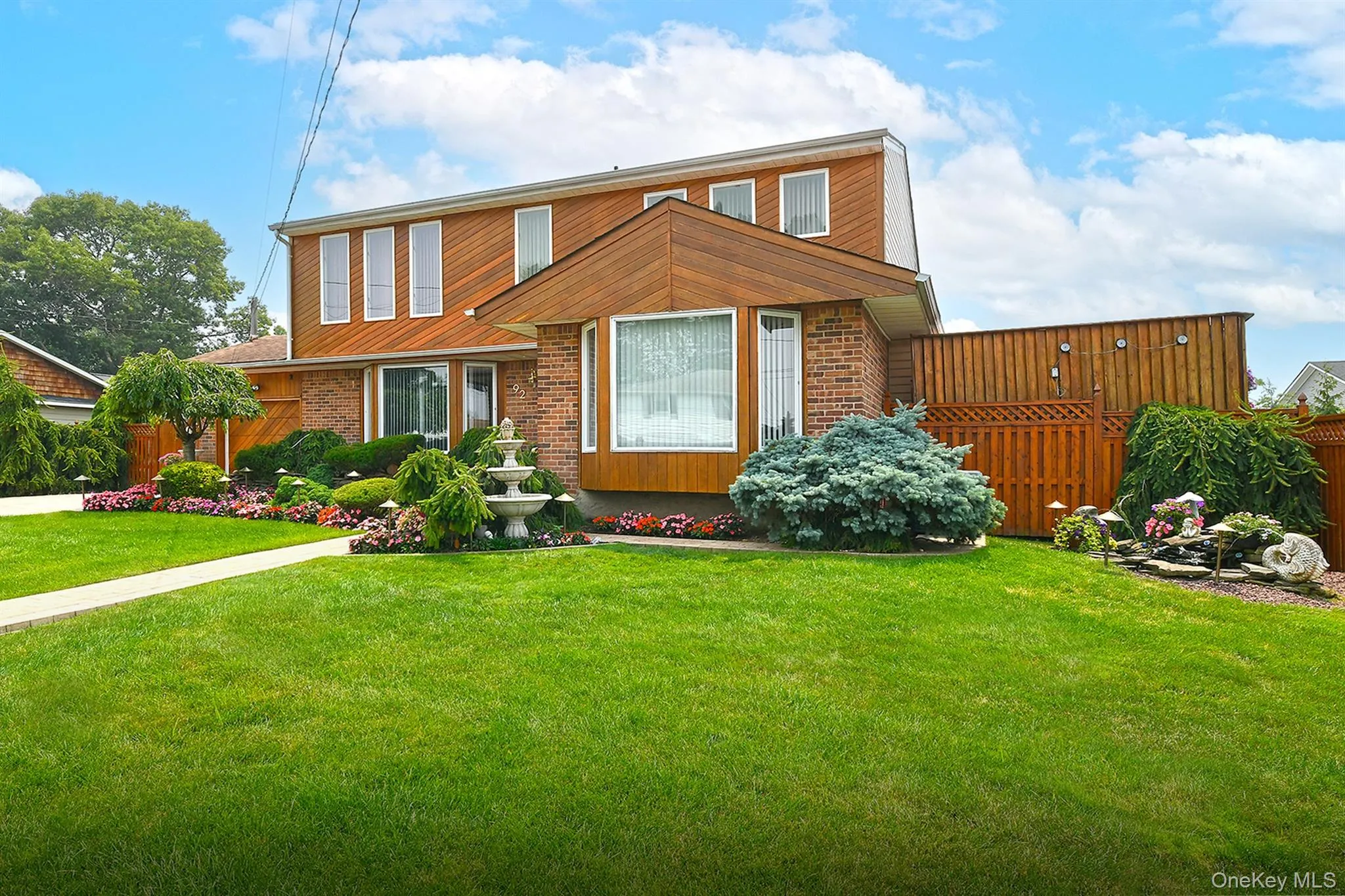 Brick and wood-finish siding exterior featuring a prominent bay window Brick and wood-finish siding exterior featuring a prominent bay window