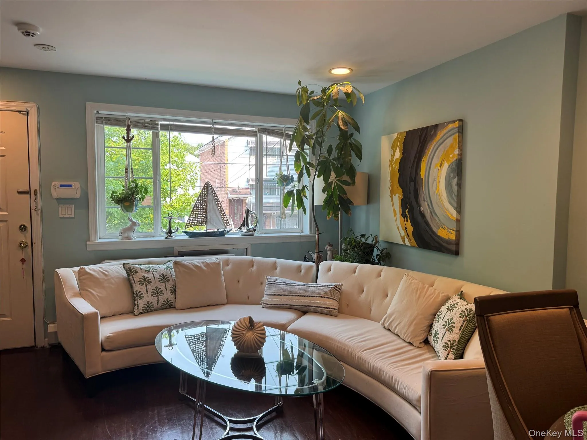 Living area featuring wood-finish flooring, recessed lighting, and a large window with natural light Living area featuring wood-finish flooring, recessed lighting, and a large window with natural light
