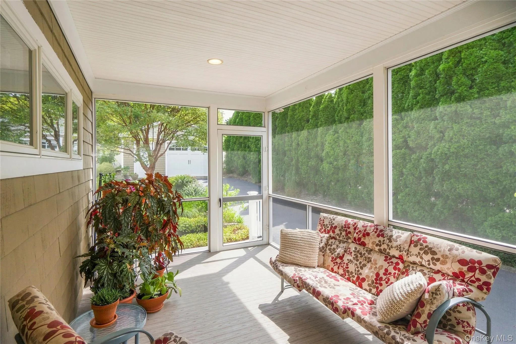Screened-in porch featuring a beadboard ceiling, recessed lighting, and a screen door Screened-in porch featuring a beadboard ceiling, recessed lighting, and a screen door