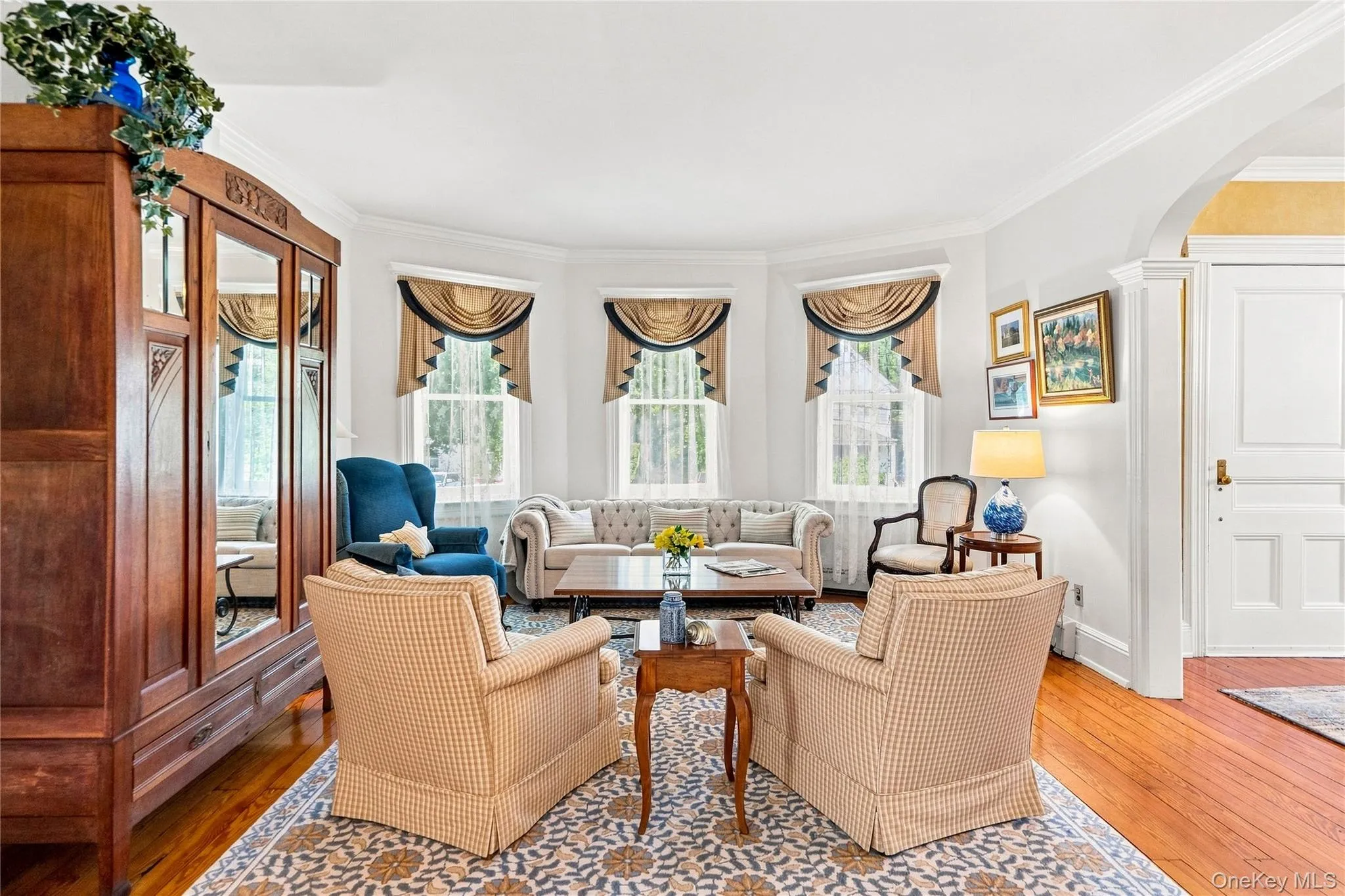 Recessed bay windows with custom valances, an arched entryway, wood flooring Recessed bay windows with custom valances, an arched entryway, wood flooring