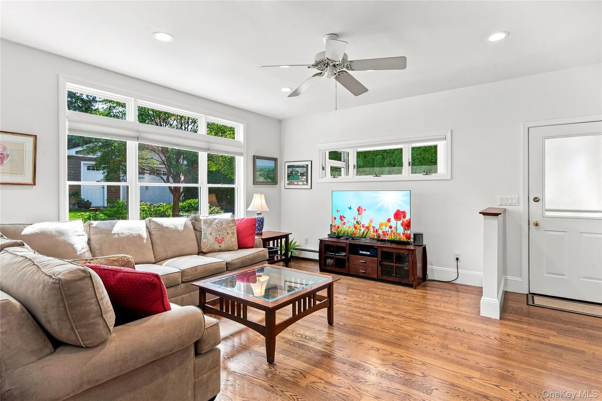 Hardwood flooring, recessed lighting, white walls, multiple windows, and a ceiling fan with integrated lighting Hardwood flooring, recessed lighting, white walls, multiple windows, and a ceiling fan with integrated lighting