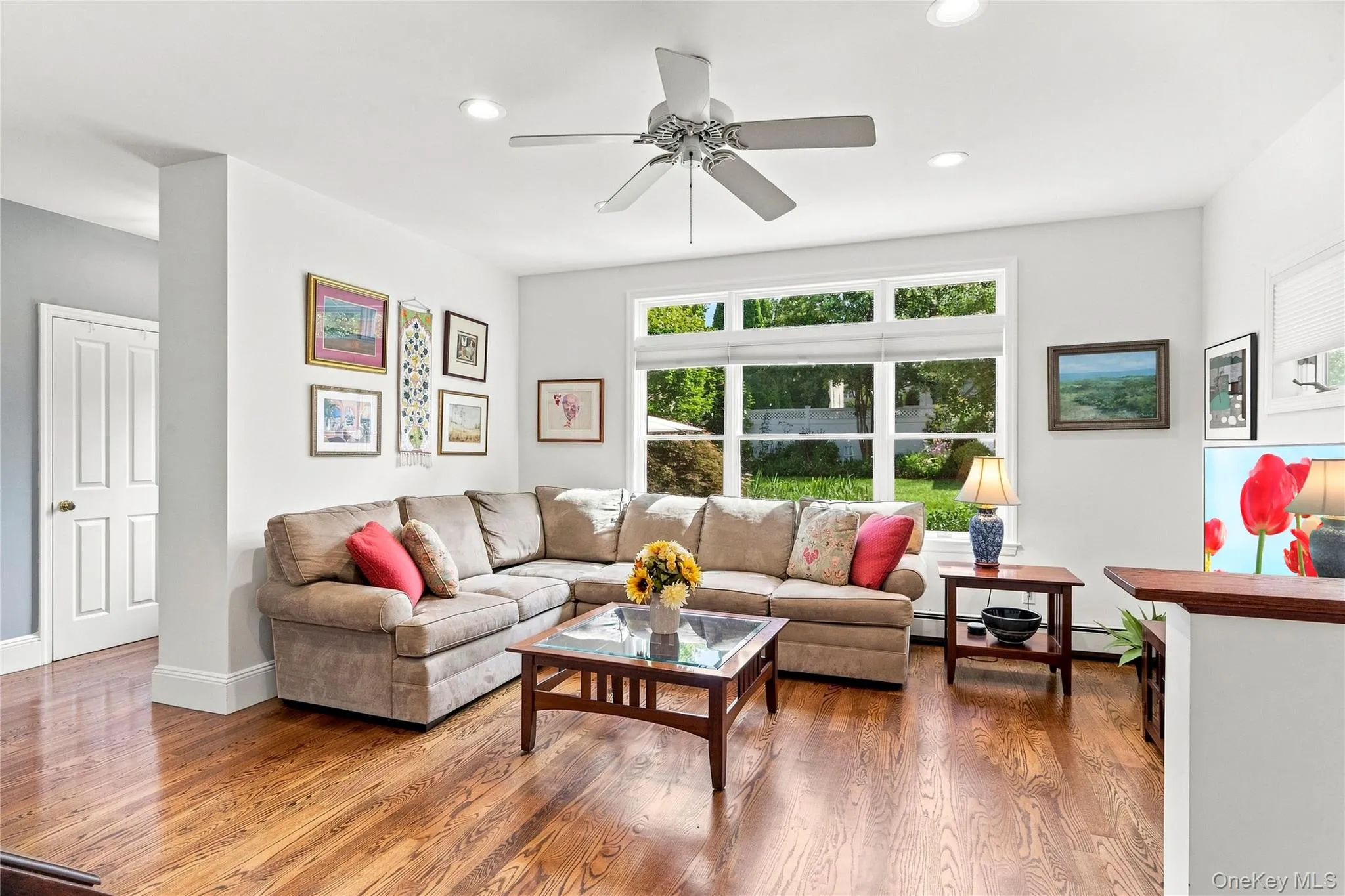 Hardwood flooring throughout, recessed ceiling lighting, a ceiling fan, and a multi-pane window Hardwood flooring throughout, recessed ceiling lighting, a ceiling fan, and a multi-pane window