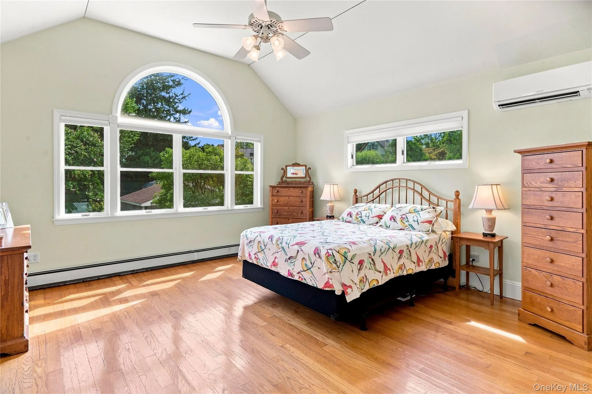 Vaulted ceiling, hardwood flooring, expansive arched window, ceiling fan, ductless mini-split system Vaulted ceiling, hardwood flooring, expansive arched window, ceiling fan, ductless mini-split system