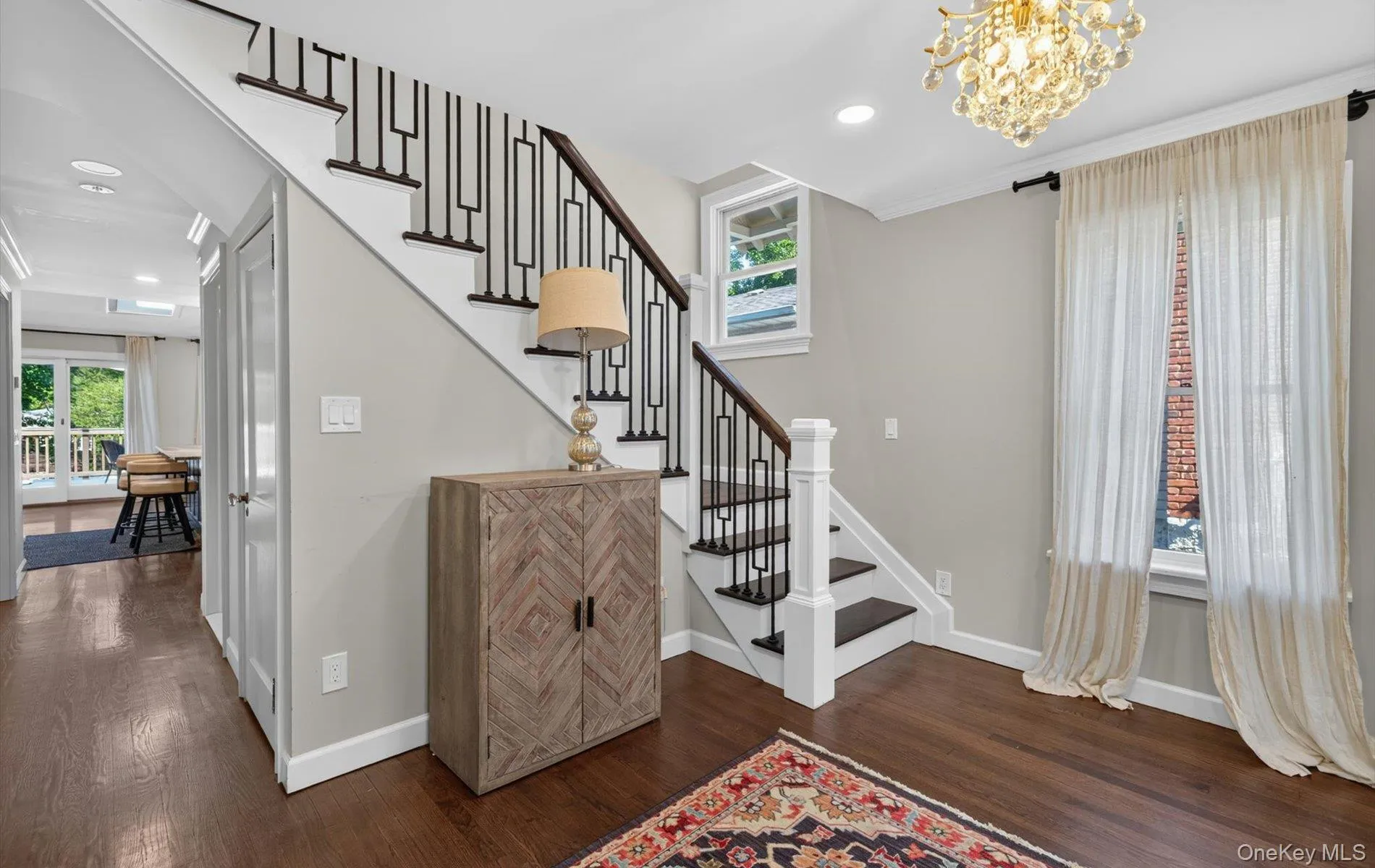 Hardwood flooring and a New staircase with decorative black metal balusters define this entry space Hardwood flooring and a New staircase with decorative black metal balusters define this entry space