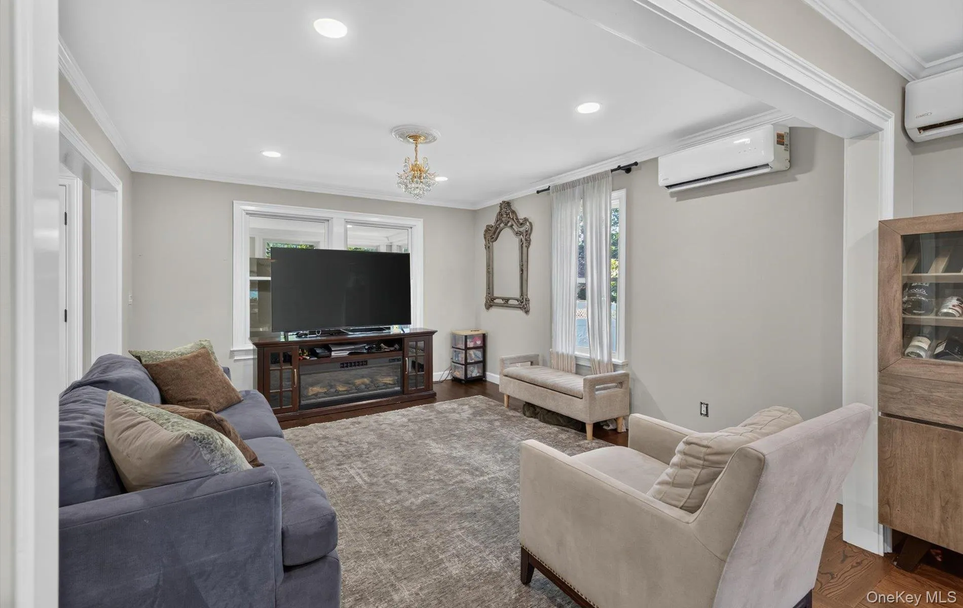 Living area featuring recessed lighting, crown molding, wood-finish flooring, and multiple windows Living area featuring recessed lighting, crown molding, wood-finish flooring, and multiple windows