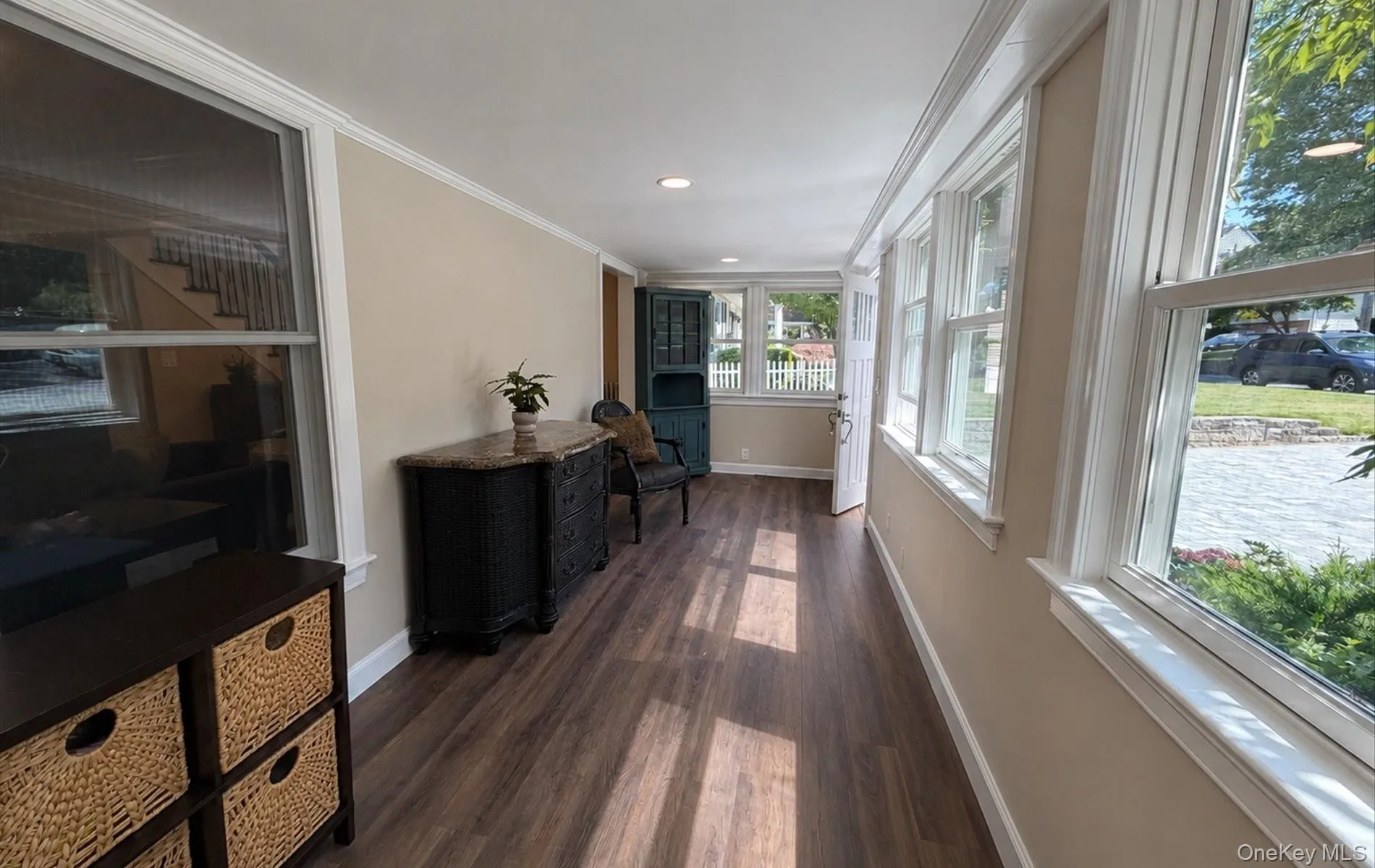 Bright sunroom featuring abundant natural light, wood-finish flooring, recessed lighting, and crisp white trimwork Bright sunroom featuring abundant natural light, wood-finish flooring, recessed lighting, and crisp white trimwork