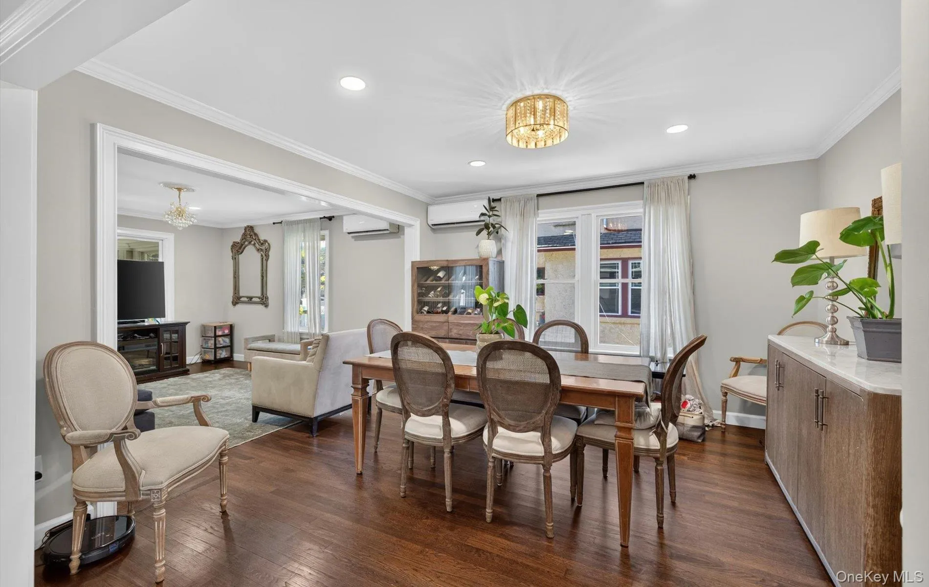 Hardwood flooring throughout, recessed lighting, crown molding, and an open entryway to an additional living space Hardwood flooring throughout, recessed lighting, crown molding, and an open entryway to an additional living space