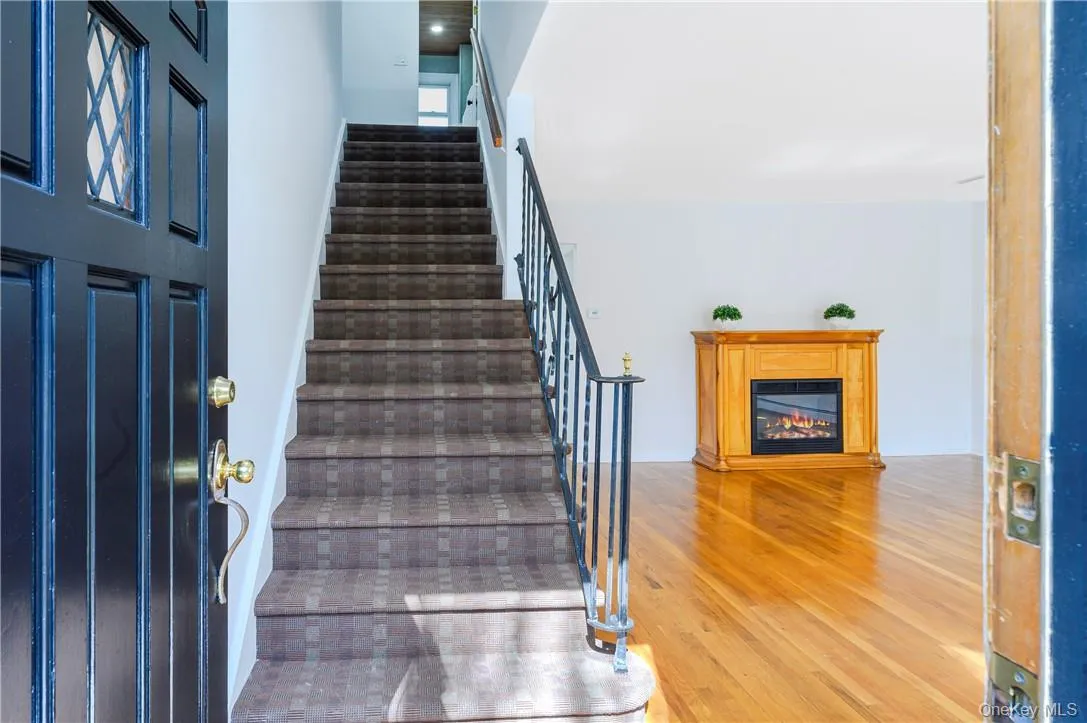 View of the stairs to the second floor and living room. View of the stairs to the second floor and living room.