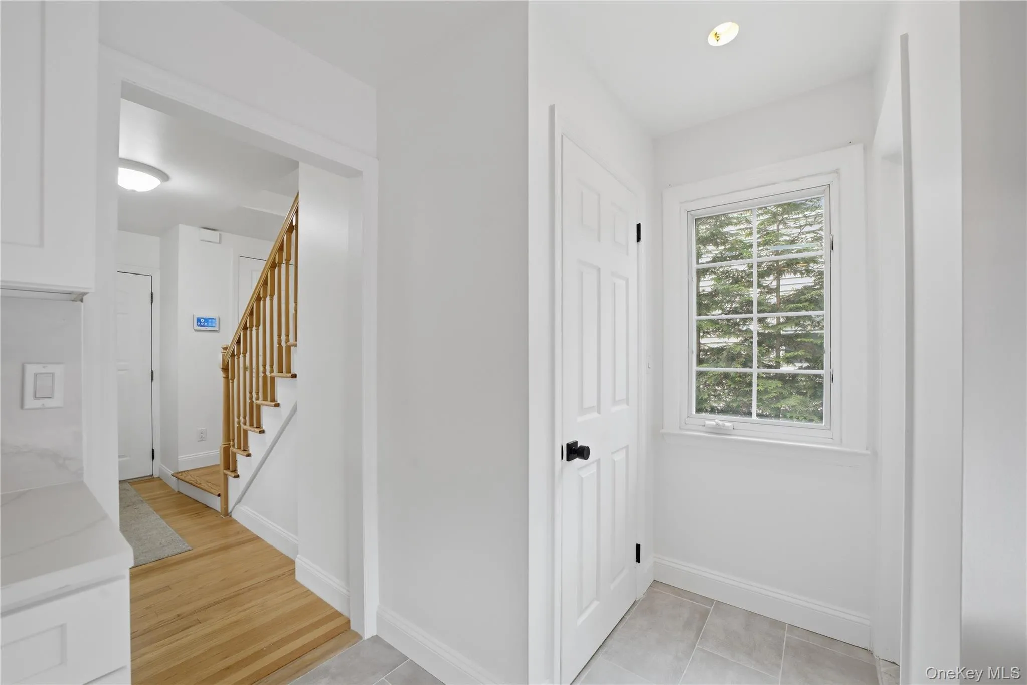 Half bath off kitchen with exit onto deck. Entry hallway to the stairs leading up to the second floor Half bath off kitchen with exit onto deck. Entry hallway to the stairs leading up to the second floor