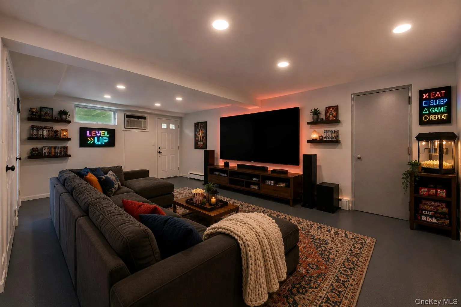 Spacious entertainment room featuring recessed ceiling lights, an accent wall with backlighting, a built-in media console, and multiple wall-mounted display shelves Spacious entertainment room featuring recessed ceiling lights, an accent wall with backlighting, a built-in media console, and multiple wall-mounted display shelves