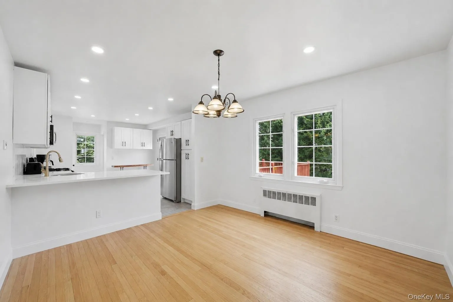 Bright dining area featuring wood-finish flooring, a multi-pane window Bright dining area featuring wood-finish flooring, a multi-pane window