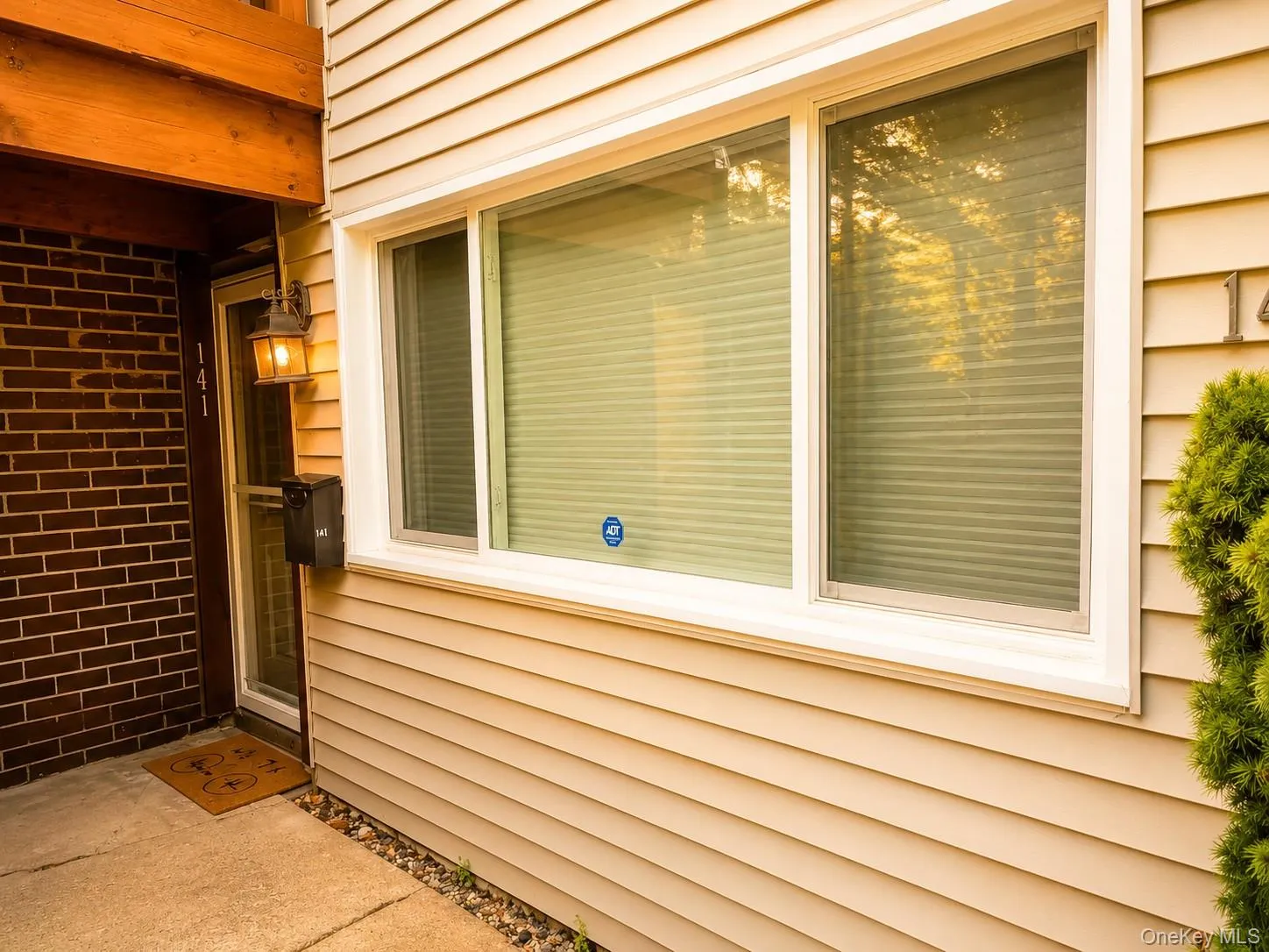 Entryway featuring brick and horizontal siding, a single-pane storm door, and an exterior wall lantern Entryway featuring brick and horizontal siding, a single-pane storm door, and an exterior wall lantern
