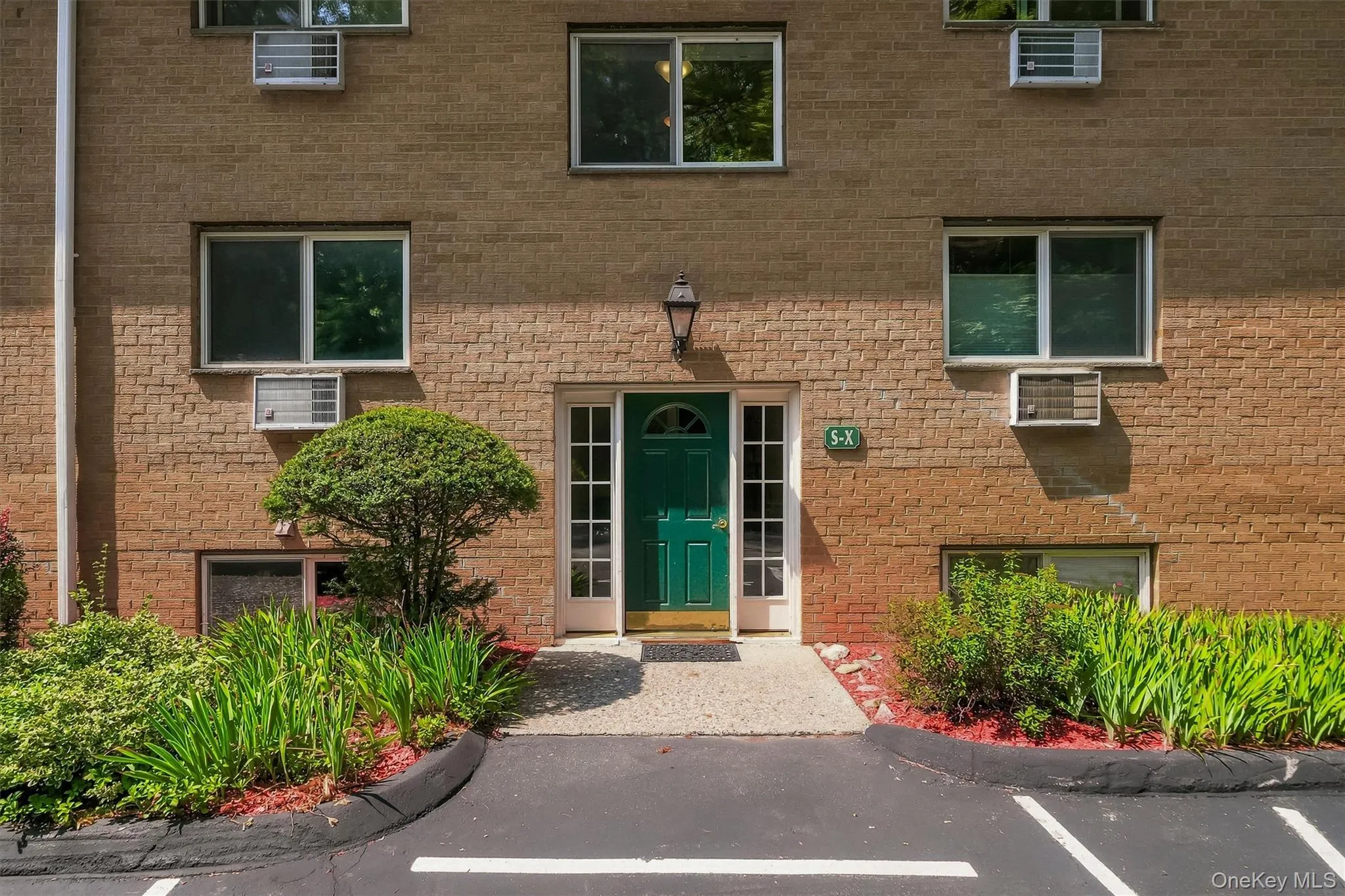 Brick exterior with a distinctive green entry door and sidelights Brick exterior with a distinctive green entry door and sidelights