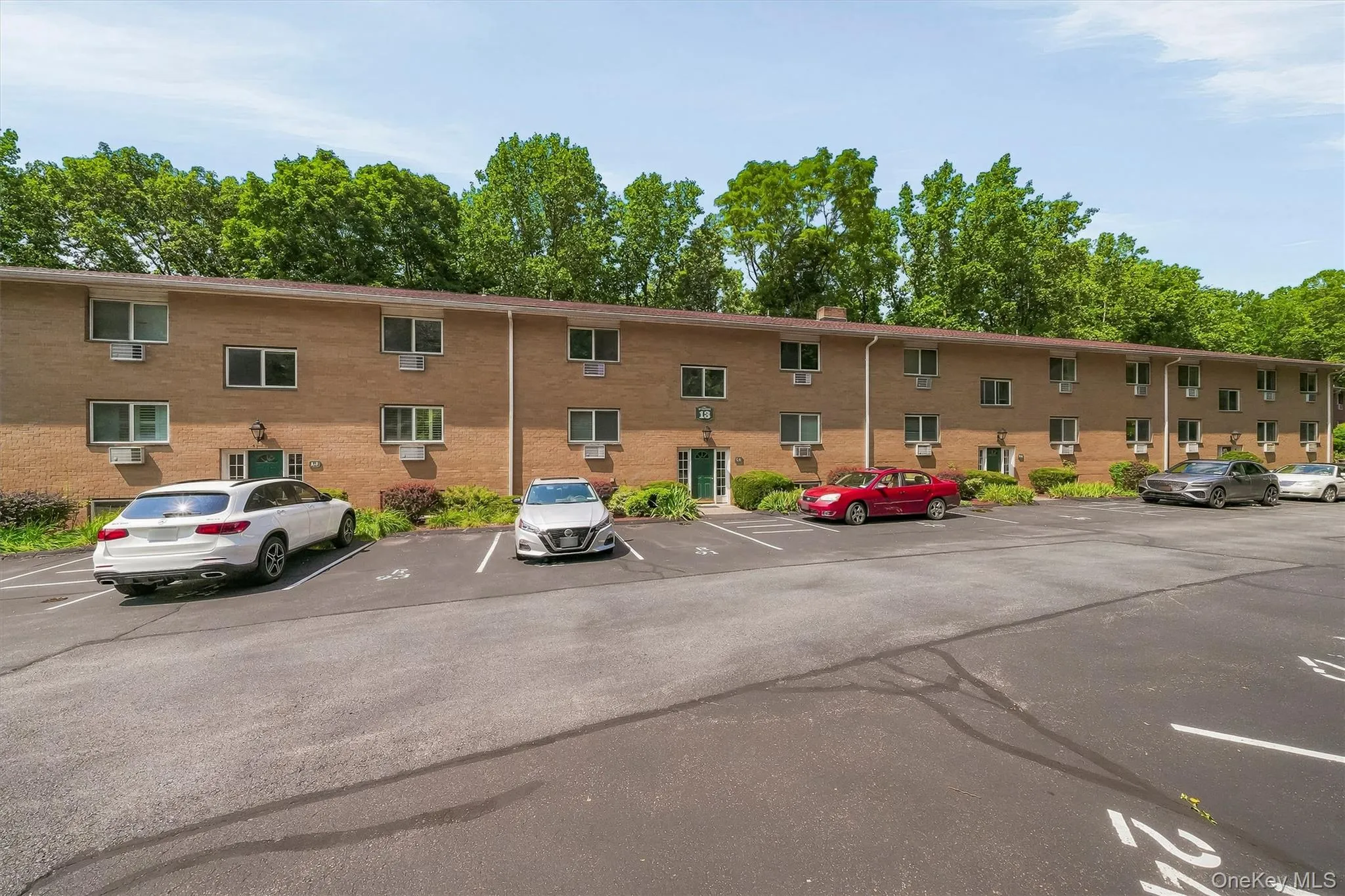 Brick multi-unit residential building featuring symmetrical fenestration with individual window units across the facade Brick multi-unit residential building featuring symmetrical fenestration with individual window units across the facade