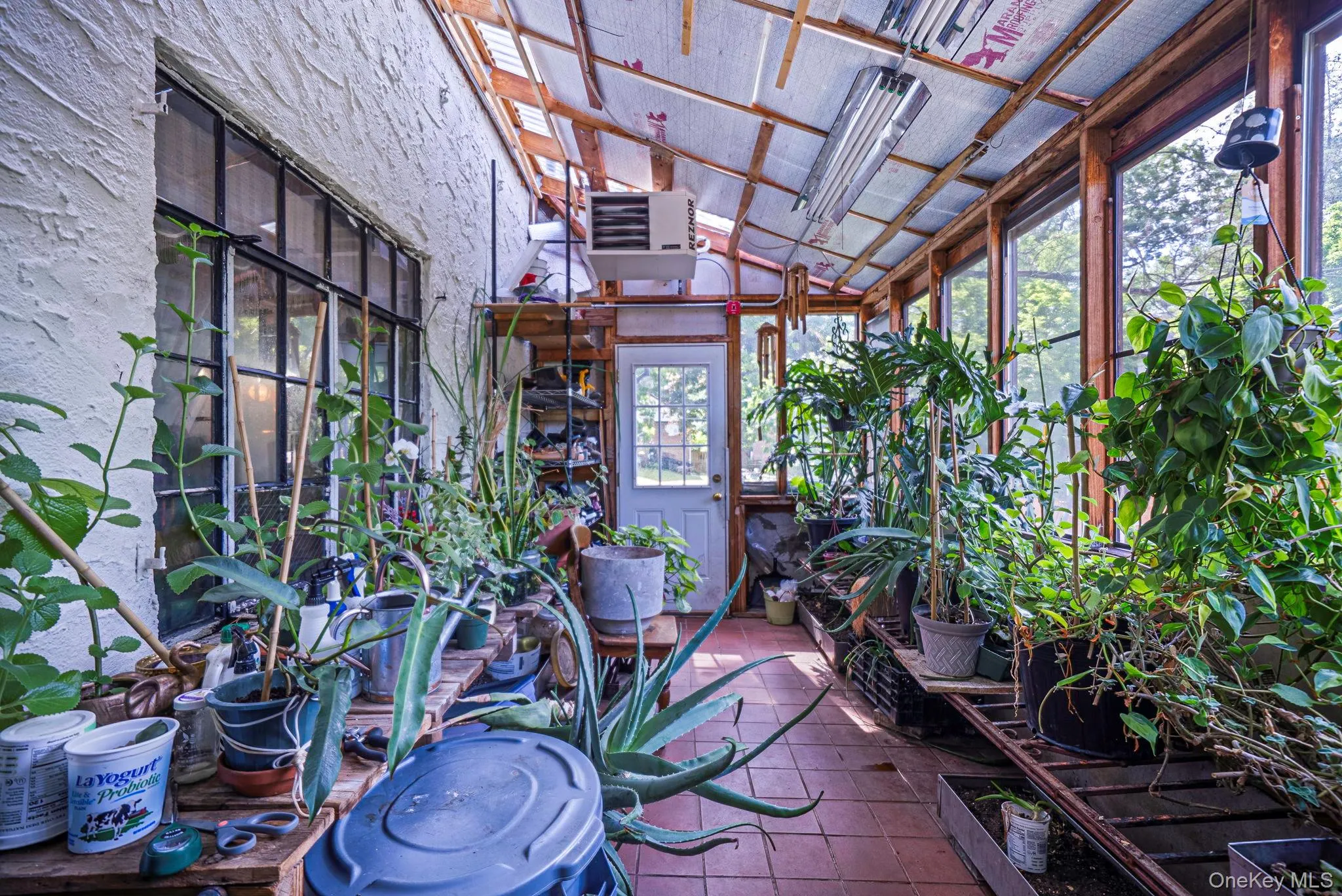 Sunroom featuring a tiled floor, exposed wood beam ceiling, and abundant natural light from multiple windows Sunroom featuring a tiled floor, exposed wood beam ceiling, and abundant natural light from multiple windows
