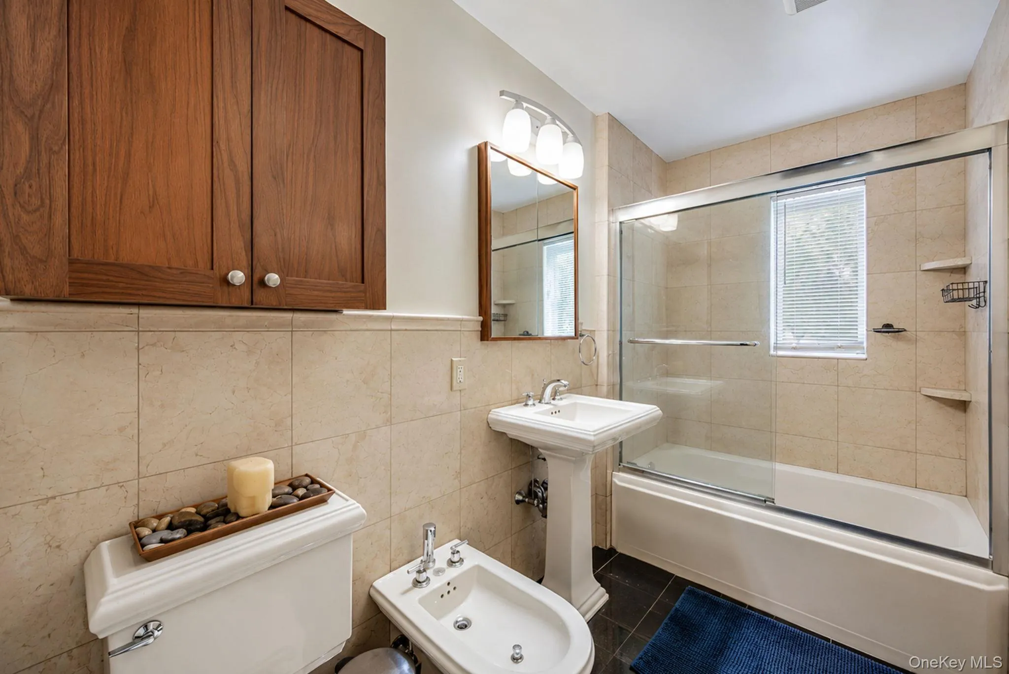 Bathroom featuring a pedestal sink, white toilet, and bidet Bathroom featuring a pedestal sink, white toilet, and bidet