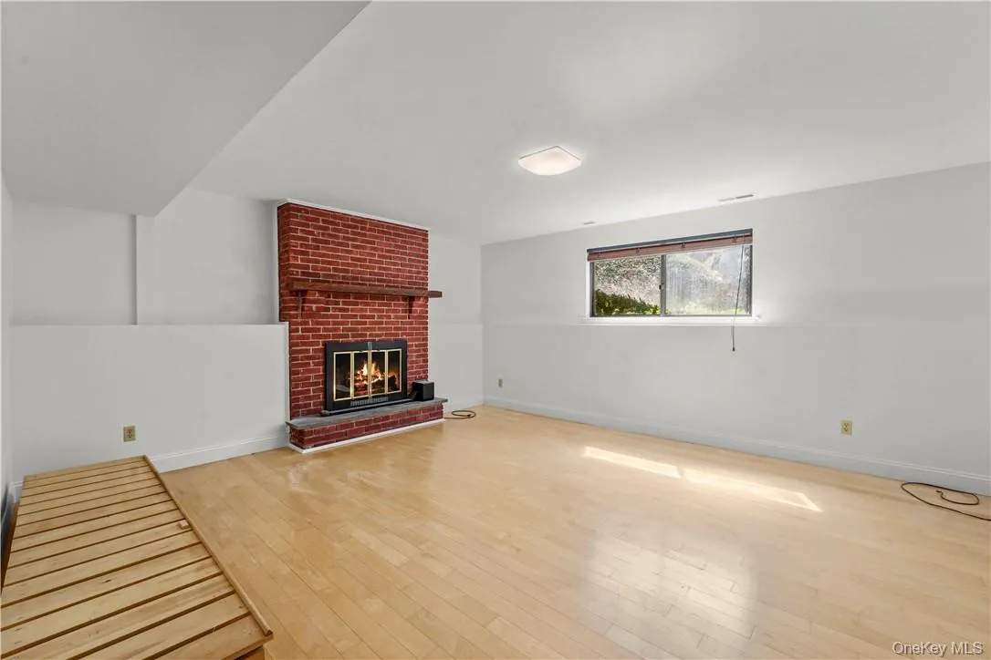 Lower level family room with traditional wood burning fireplace. Lower level family room with traditional wood burning fireplace.