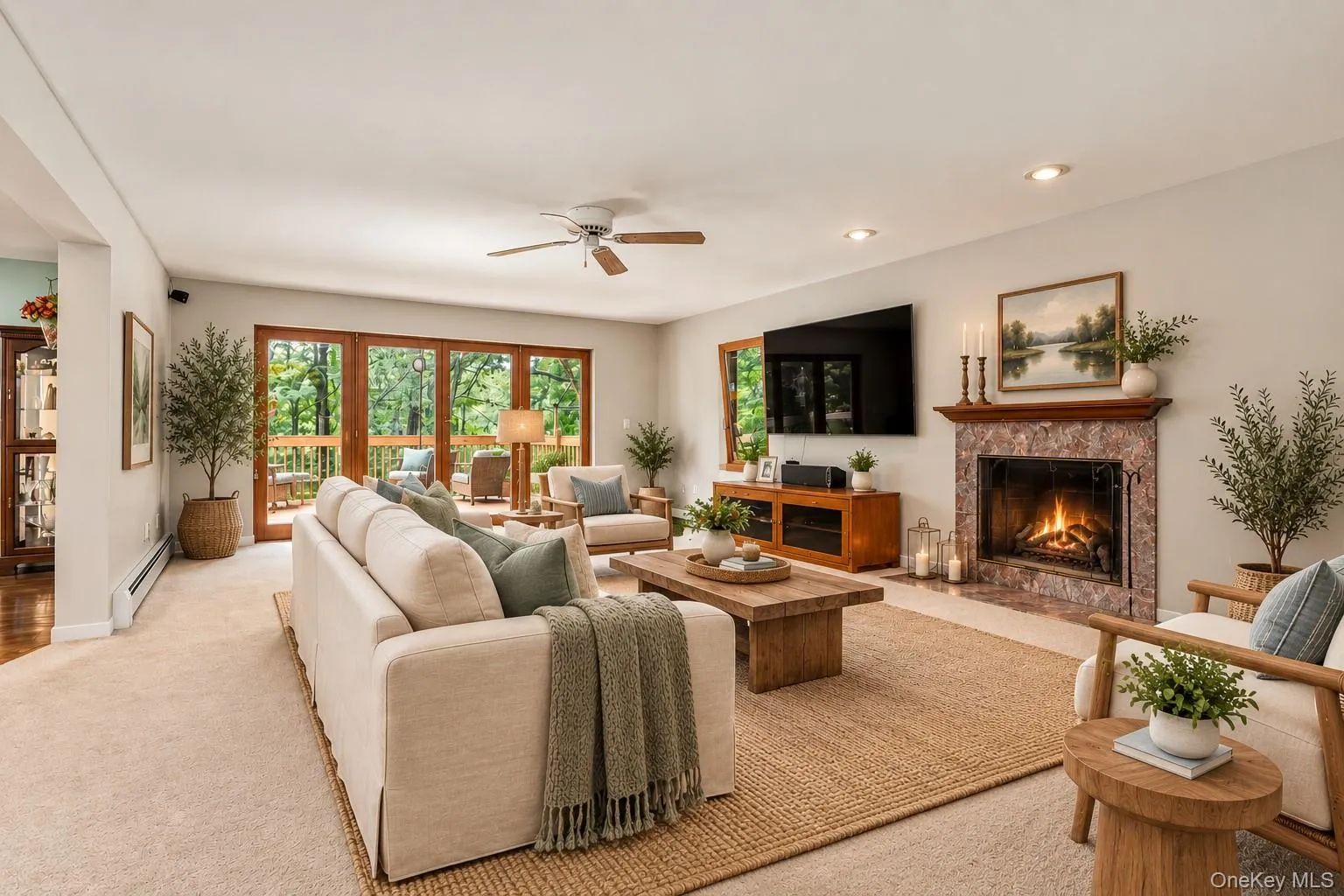 Virtually staged to showcase the living room’s contemporary comfort and generous proportions, highlighting the beautiful fireplace and expansive mahogany-trimmed doors that open to the deck and surrounding views. Virtually staged to showcase the living room’s contemporary comfort and generous proportions, highlighting the beautiful fireplace and expansive mahogany-trimmed doors that open to the deck and surrounding views.